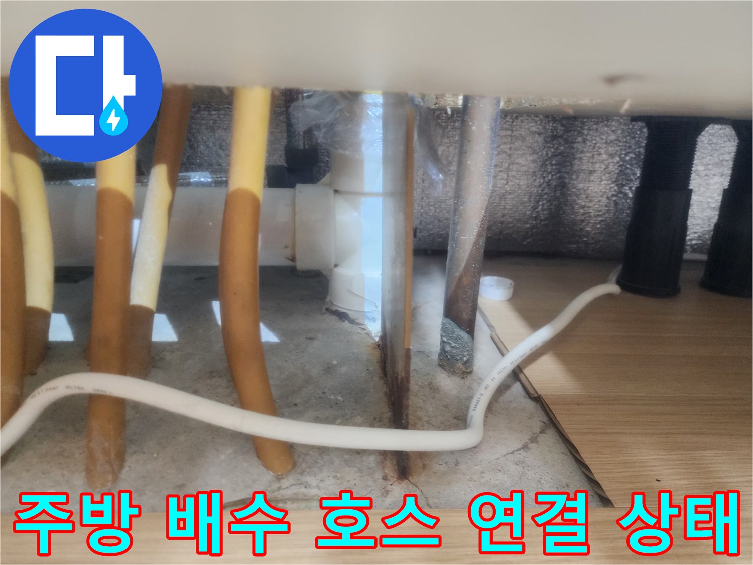노란색 싱크대 배수 호스와 바닥 배관의 접촉 부위