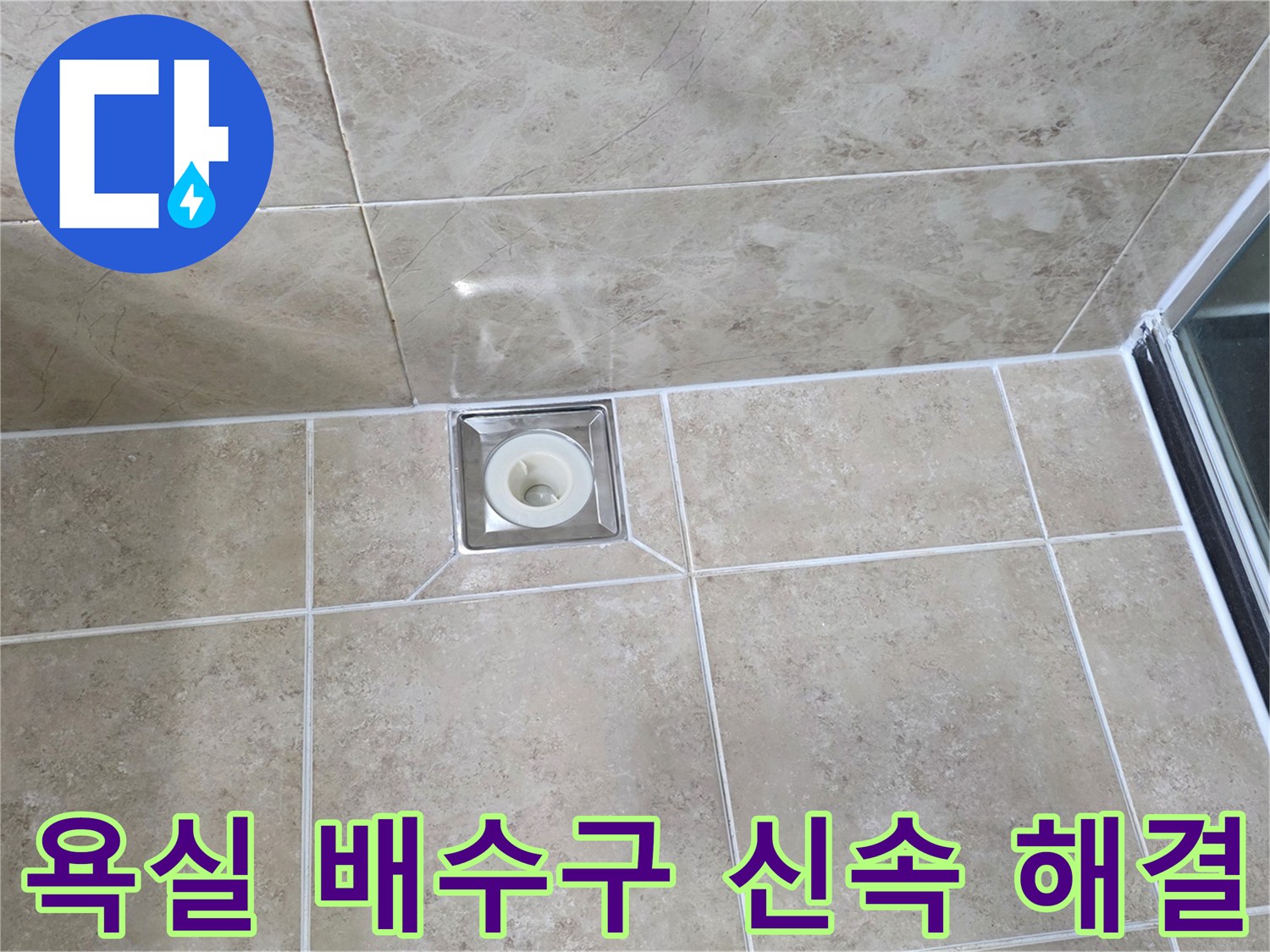 깨끗하게 시공된 욕실 타일 중앙에-사각형 배수구가 위치하며-주변 마감 상태를 면밀히 관찰하는 사진입니다