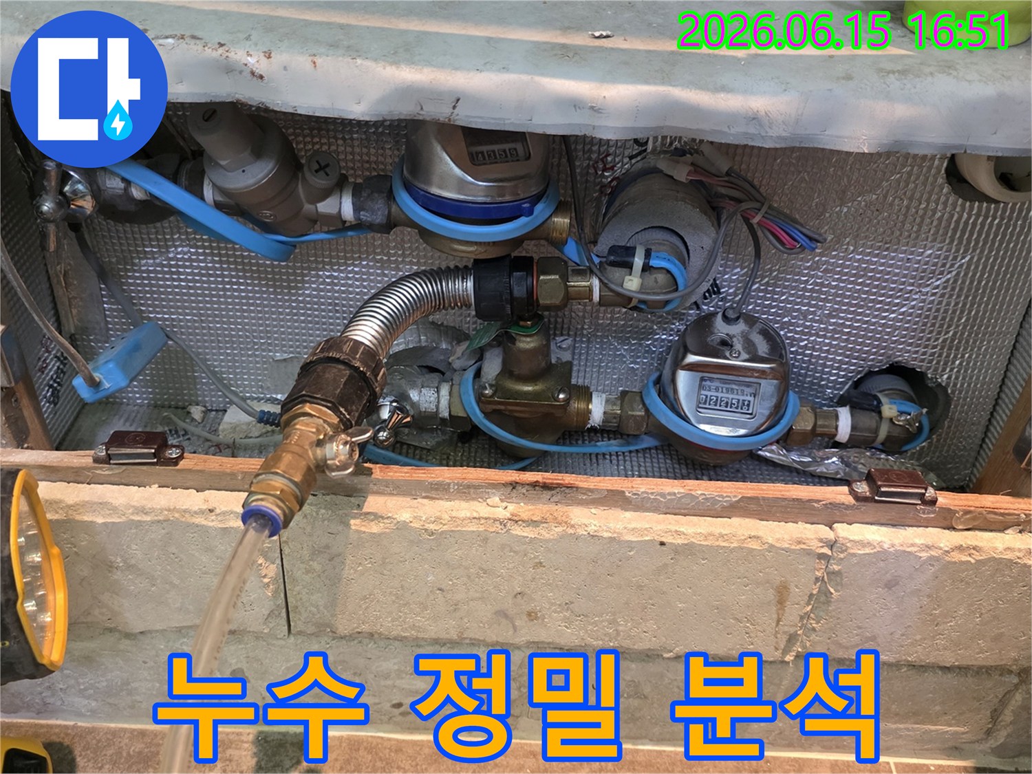 배관에 연결된 다양한 측정 장비와 호스-누수 엔지니어가 현장에서 배관 상태를 정밀하게 분석하는 모습입니다.