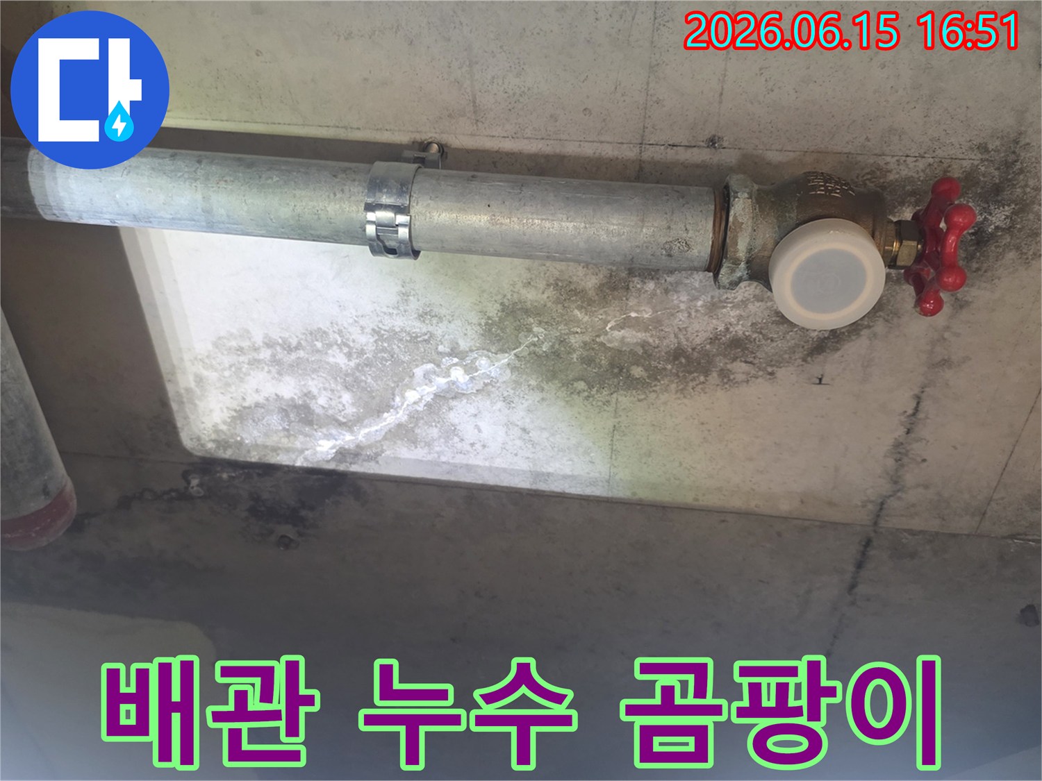 이 이미지는 천장 배관 주변에 생긴 누수로-인한 하얀 석회질 자국과-검은 곰팡이 얼룩을 보여주며-배관의 노후 상태를 나타냅니다