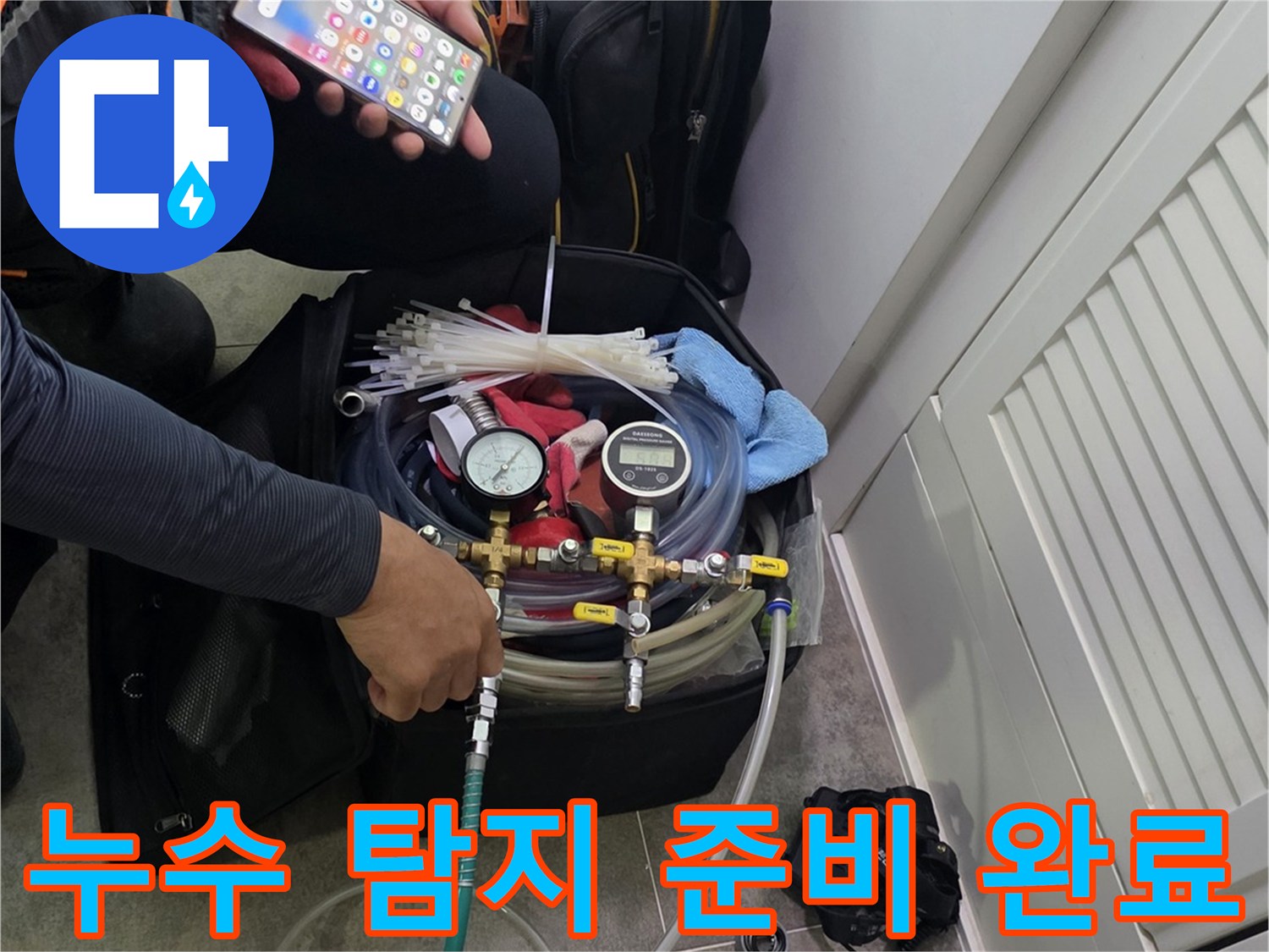 현장에서 누수 탐지 장비를-조작하며-스마트폰으로 데이터를 분석하는 엔지니어