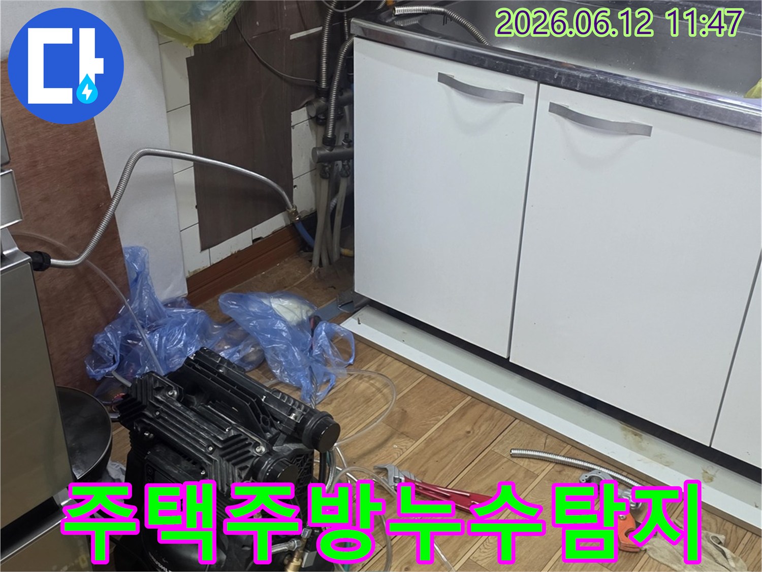 주택 주방 싱크대 하부에서-누수 탐지 장비를 연결하여-배관 상태를 정밀하게 점검하는 모습