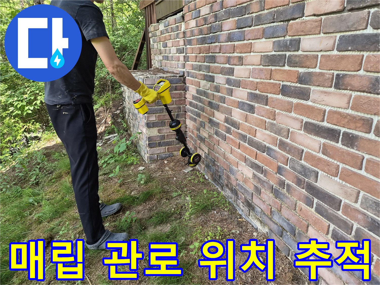 건물 외벽 옆에서-배관의 경로를 찾기 위해-장비를 조작하는 모습