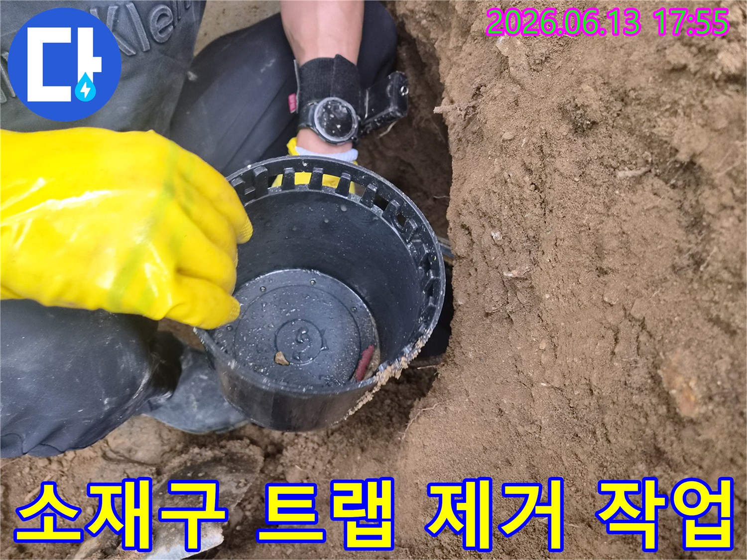 노란색 장갑을 착용한 엔지니어가 굴착한 지점에서 소재구 트랩을 들어올리는 모습