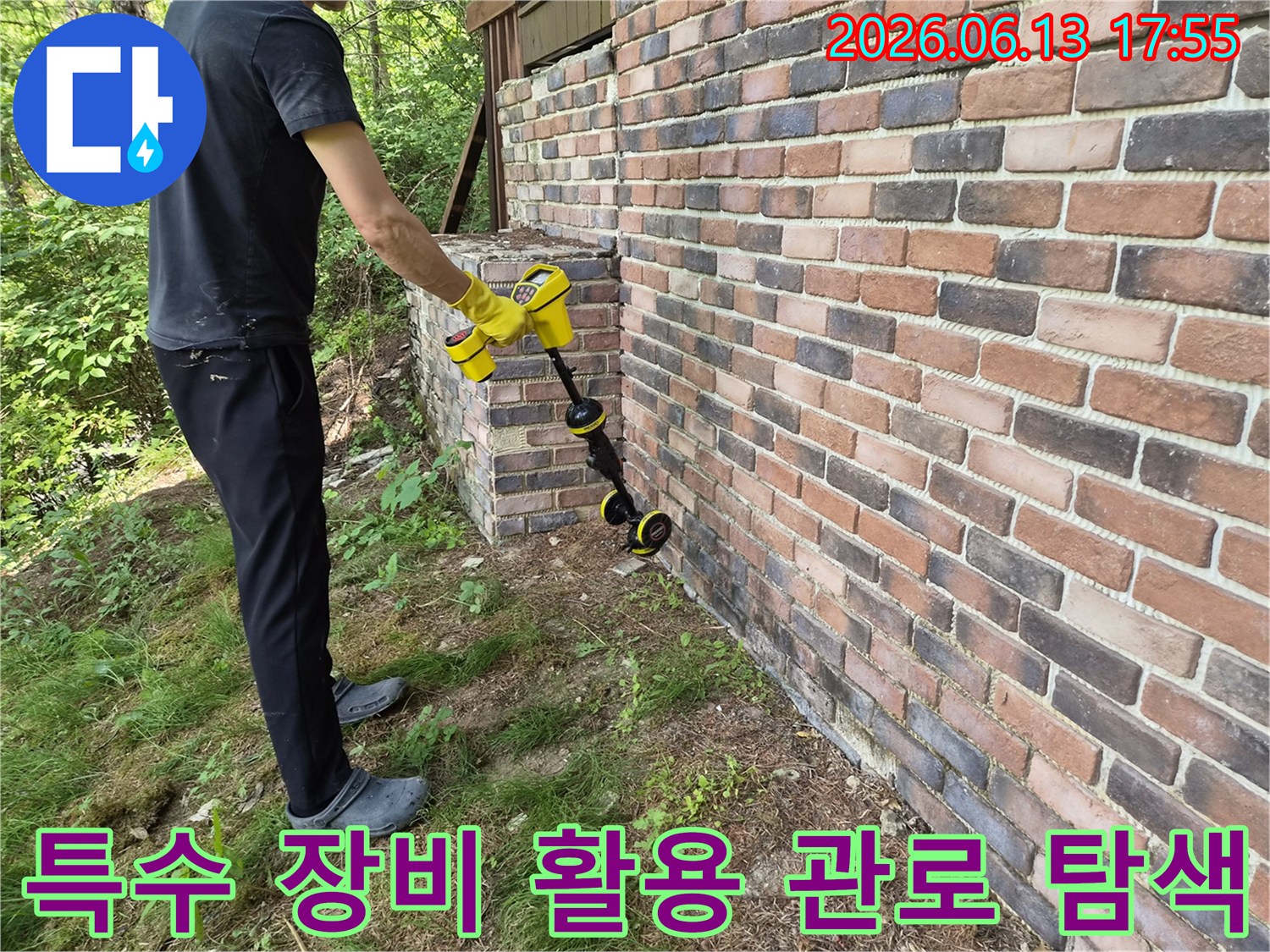 작업자가 노란색 관로 탐지기를 들고 배관 경로를 추적하는 현장 사진