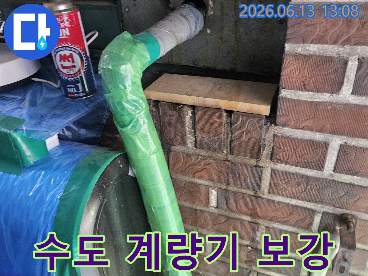 벽에서 나온 수도 배관의 계량기 연결 부위를-특수 테이프로 감싸고 토치로 열처리하여 보강하는 모습