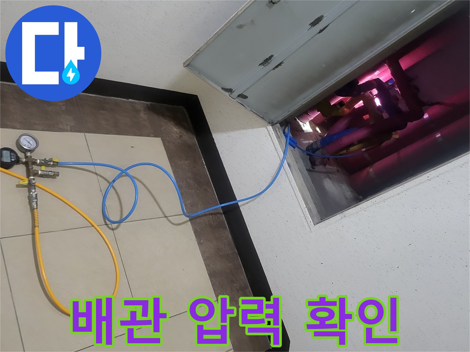 배관 점검 중-디지털 게이지로 누수 여부를 확인하는 장면