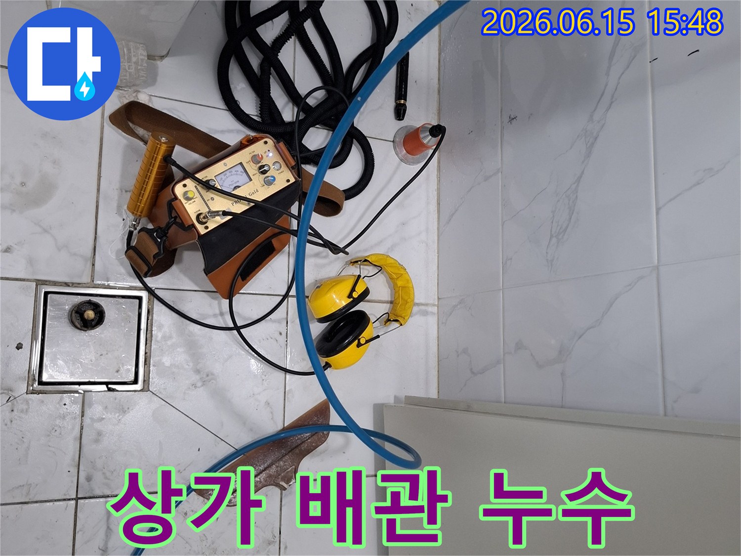 상가 배관 누수 탐지를 위해-전문 장비들이-화장실 바닥에 배치되어-정밀한 탐지 작업을 준비하고 있습니다