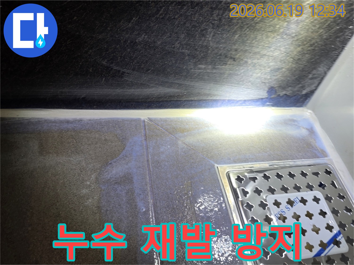 욕실-바닥-타일과-배수구-주변에-물이-고여있는-누수-현장에서-재발-방지를-위한-시공-계획을-세우는-사진입니다