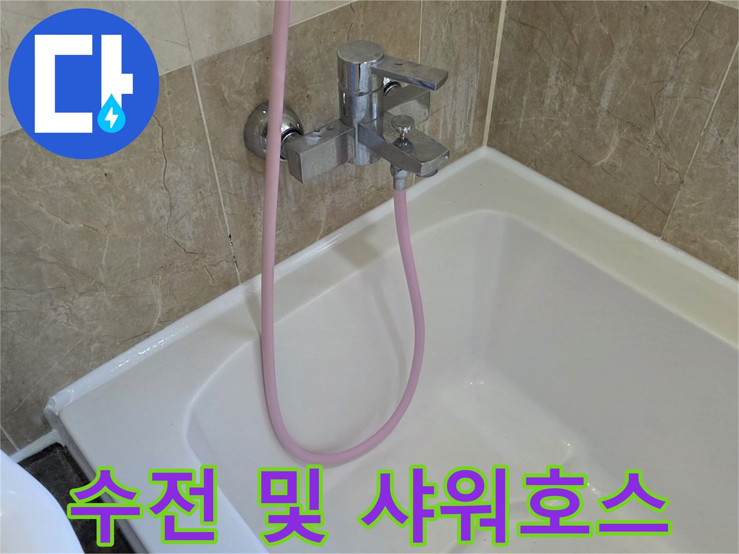 금속 재질의 수전과 분홍색 호스가 설치된 욕실 모습입니다.