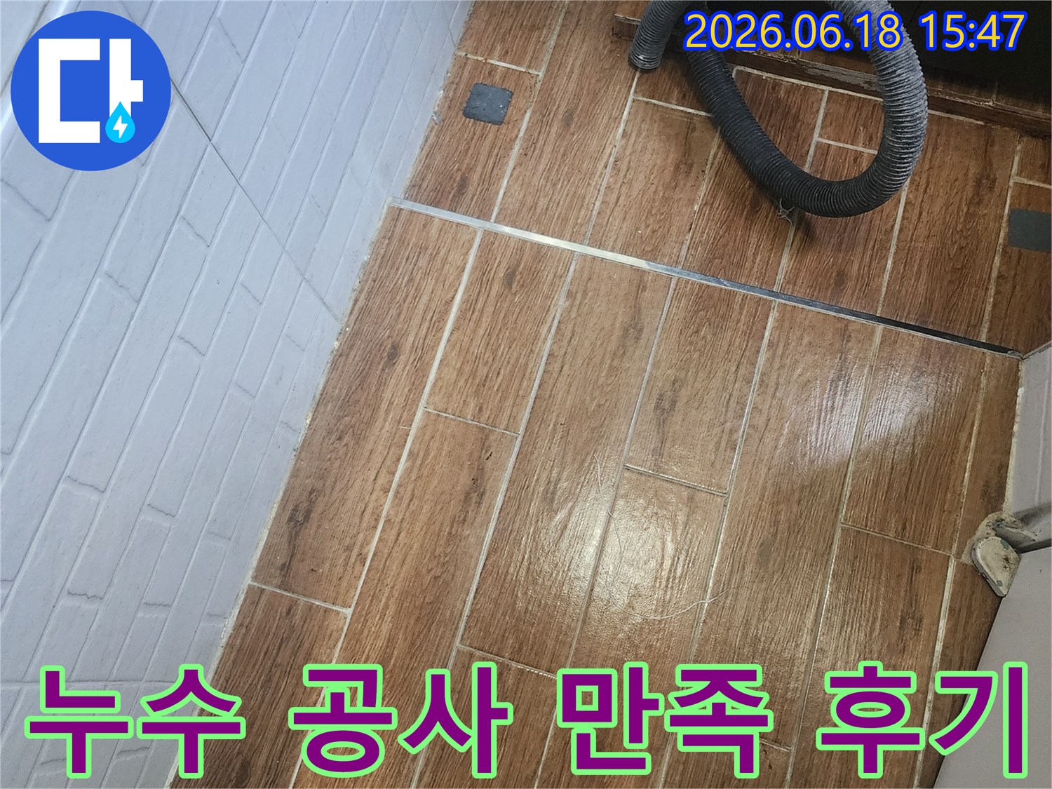 강서구 염창동에서 만족도 높은 누수 공사 후기를 위한 탐지 및 작업이 진행 중인 현장 사진입니다-바닥 타일 위에 검은색 호스가 놓여 있습니다.