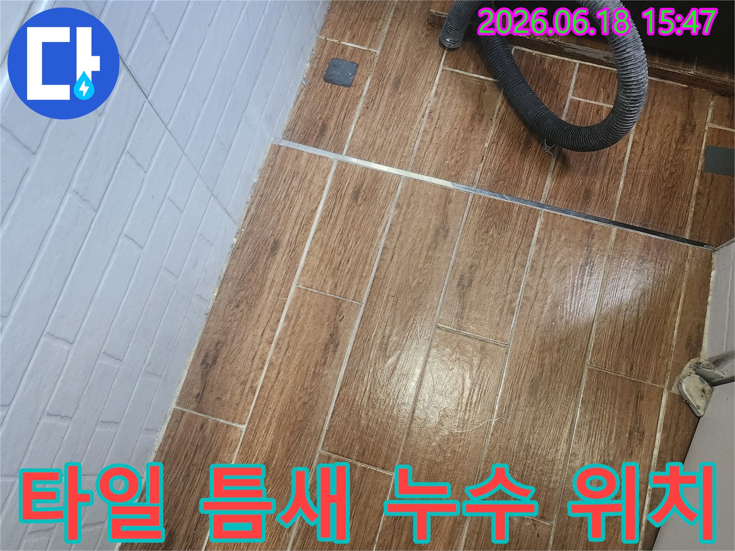 강서구 염창동에서 타일 틈새 누수의 정확한 위치를 파악하기 위한 탐지 작업이 진행 중인 현장입니다-바닥 타일 위에 검은색 호스가 놓여 있습니다.
