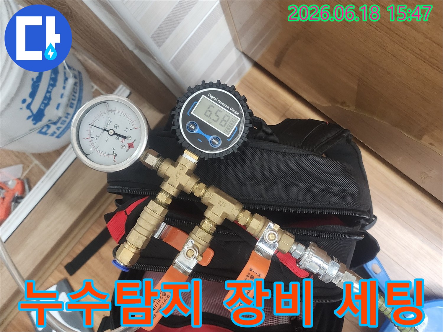 누수 탐지 전문가가-배관에 압력 측정 장비를-정확하게 연결하여-누수 여부를 확인하는 장면