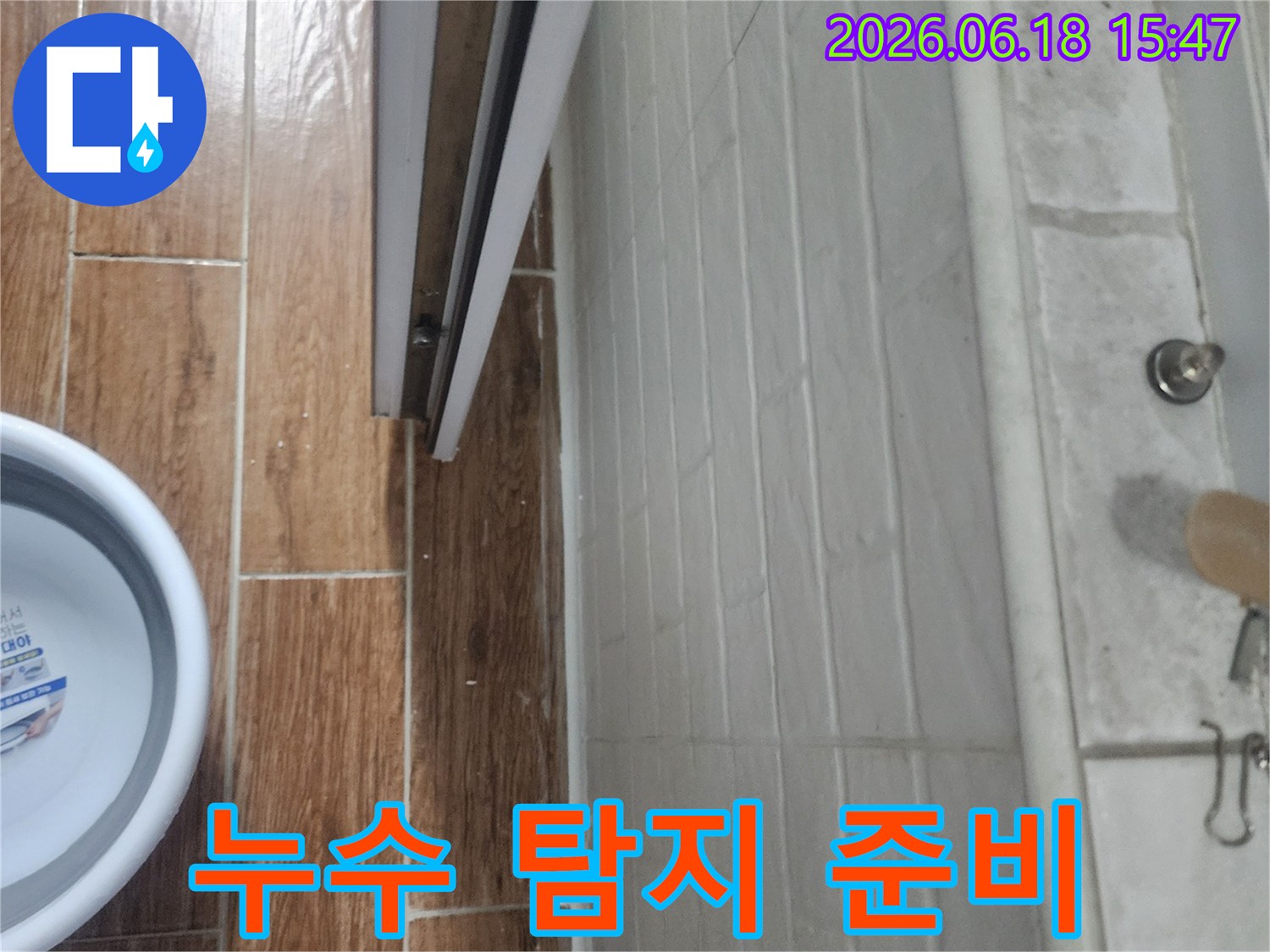 누수-탐지를-위해-욕실-내부-환경을-살피며-물통이-놓여있는-현장-사진입니다.