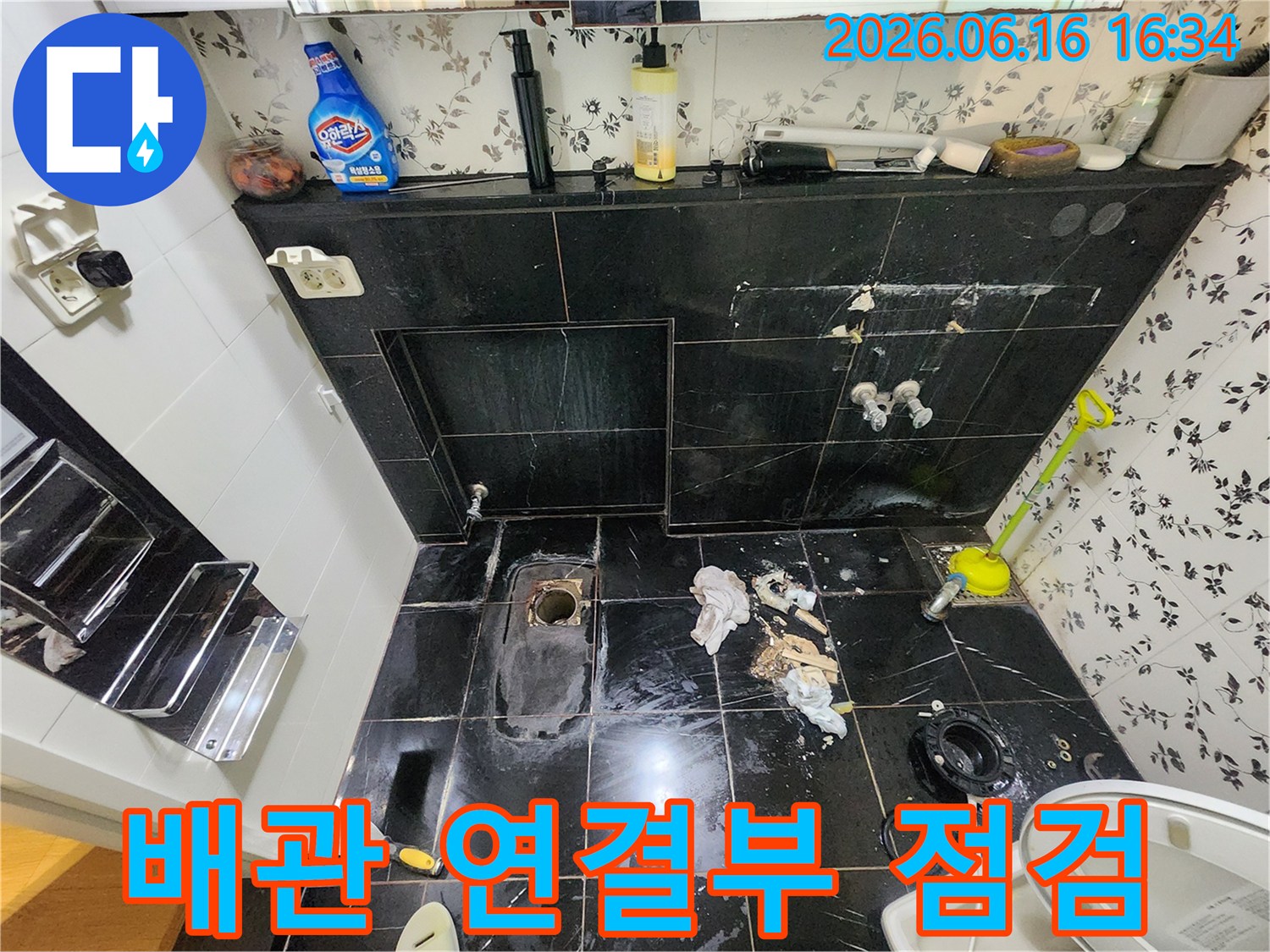 마포구 망원동 화장실 누수 현장에서-바닥 타일 철거 후-배관 연결 부위를 꼼꼼히 점검하는 모습