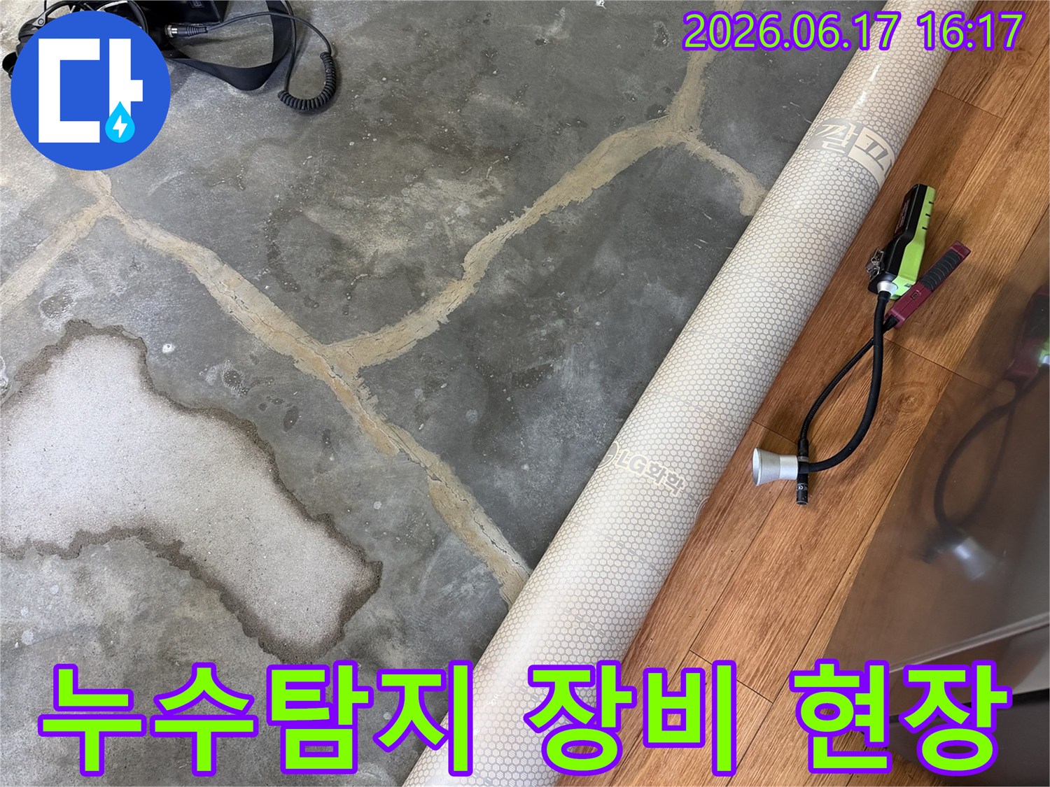 누수-탐지-장비가-바닥에-놓여있고-물에-젖어-변색된-콘크리트-바닥의-모습을-보여주는-사진