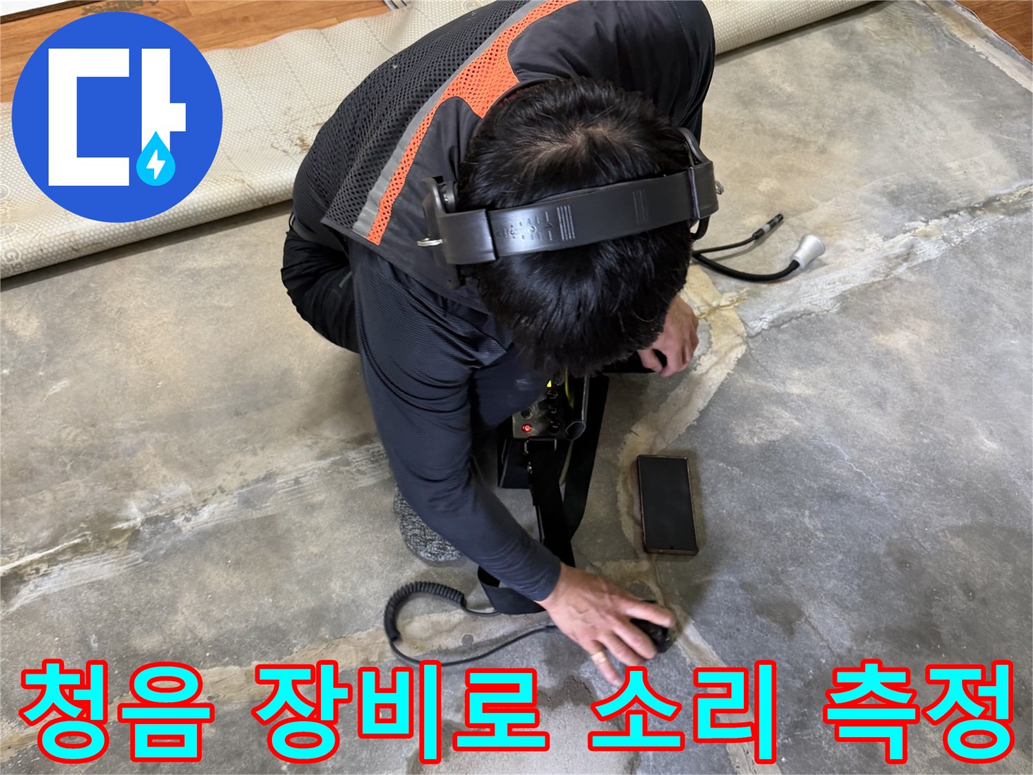 바닥의 미세한 소리를 찾기 위해 청음기를 사용 중인 작업자