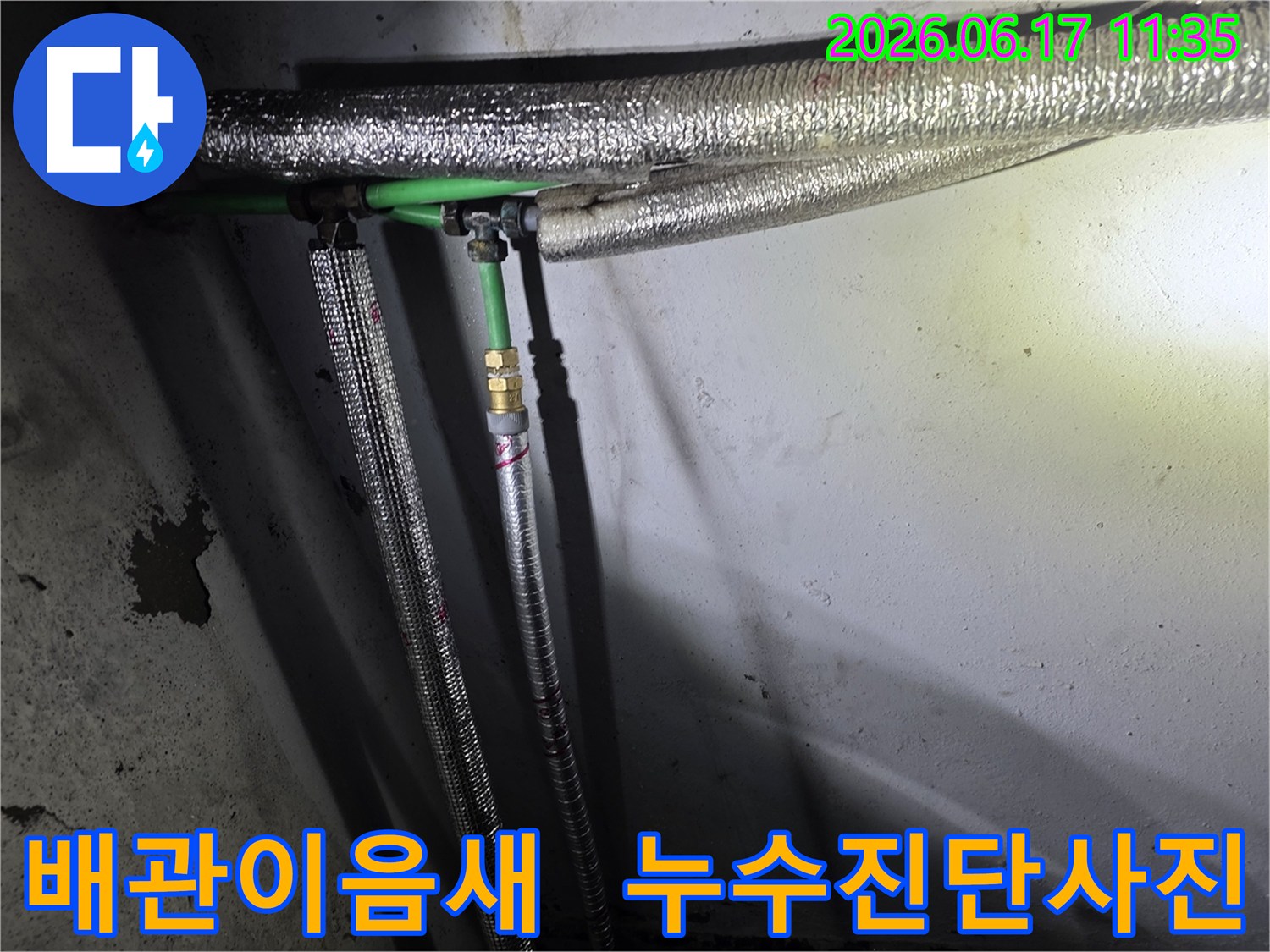 보온 처리된-배관과-녹색 파이프가-얽혀 있는-누수 의심 지역의-클로즈업 이미지