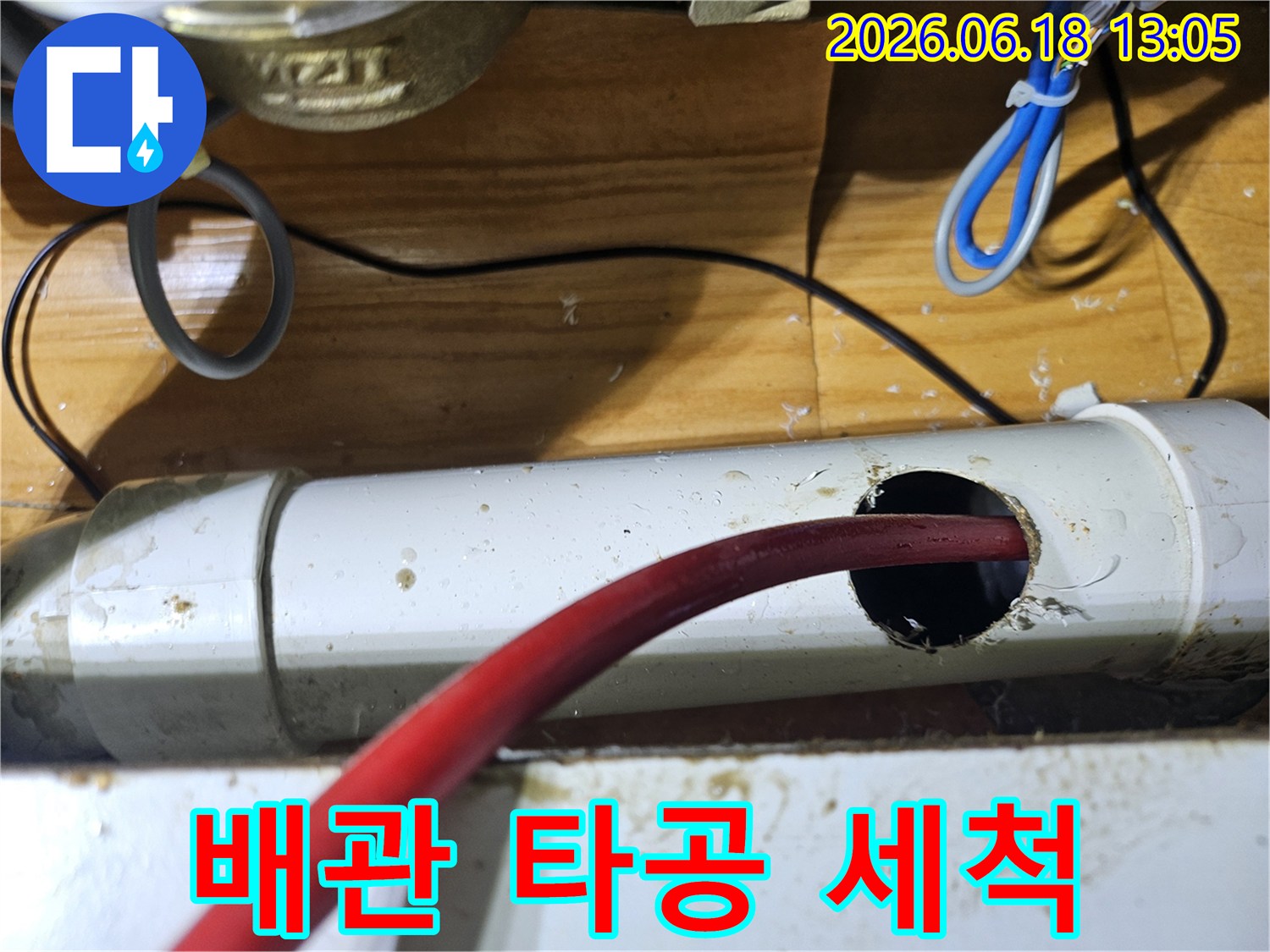 누수 지점을 확인하고-배관에 구멍을 뚫어-내부를 청소하는 모습입니다.