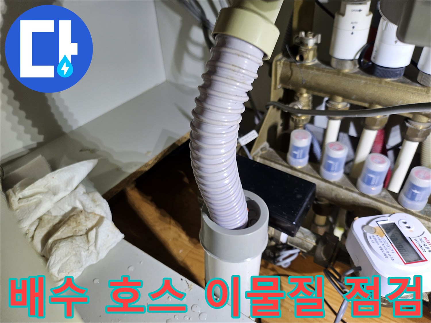 배수 호스 내부에-이물질이 쌓여있는지 확인하고-배수 흐름을 방해하는 요소를 점검하는 모습