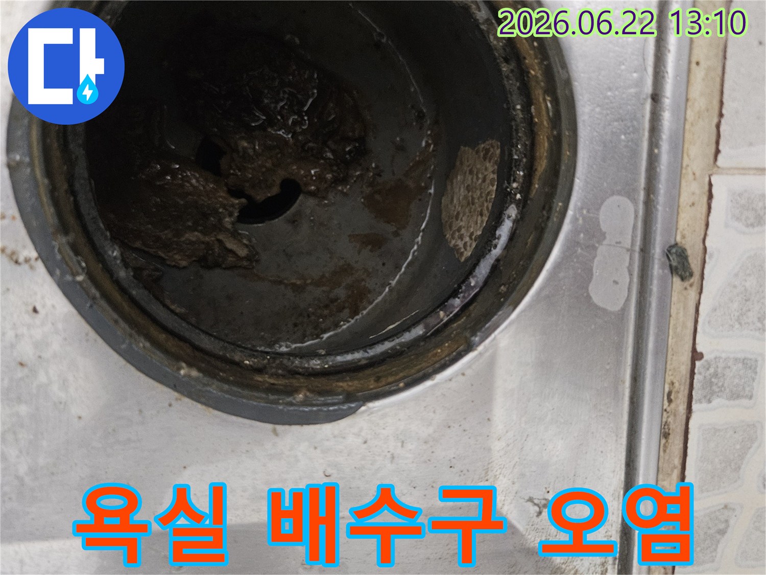 이 이미지는 오수관 막힘의 원인이 되는-욕실 배수구의 심각한 오염 상태를 보여줍니다.