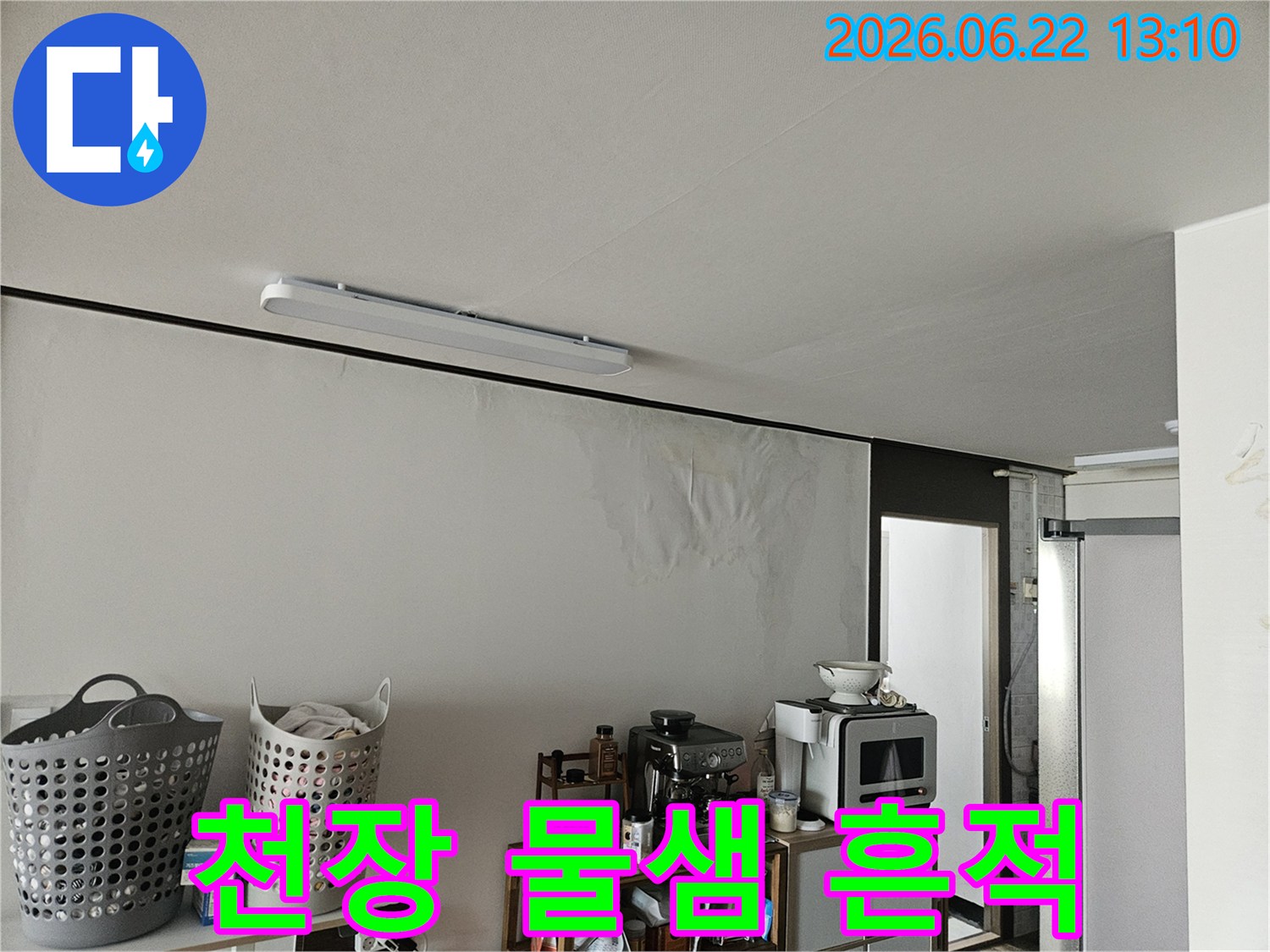 이 이미지는 천장 누수로 인해 벽면이 심하게 젖어-벽지가 들뜨고 곰팡이가 생기기 시작한 아파트 내부의 모습을 보여줍니다.