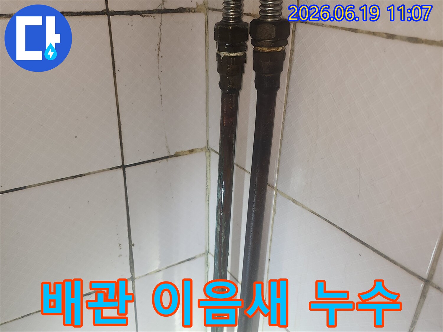 배관 이음새 부분에 물이 새어 나온 흔적이 보이며-타일 변색과 오염이 관찰됩니다