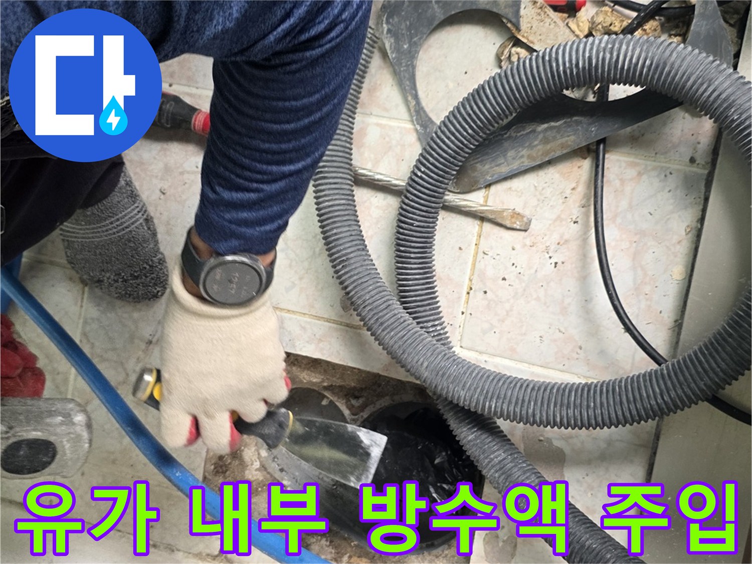 장갑을 낀 작업자가 배수구 안쪽으로 방수재를 채우고 있습니다.