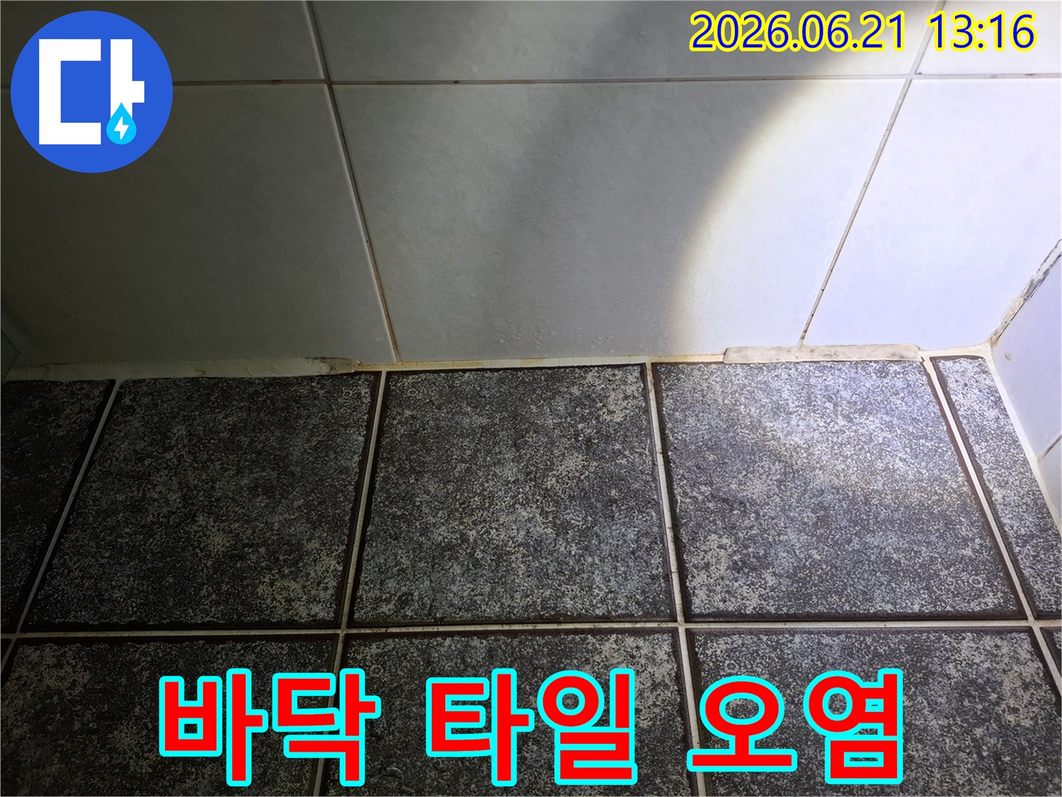 회색 타일과-검은색 타일이 만나는-경계면의-물때와 오염-상태를 나타냅니다
