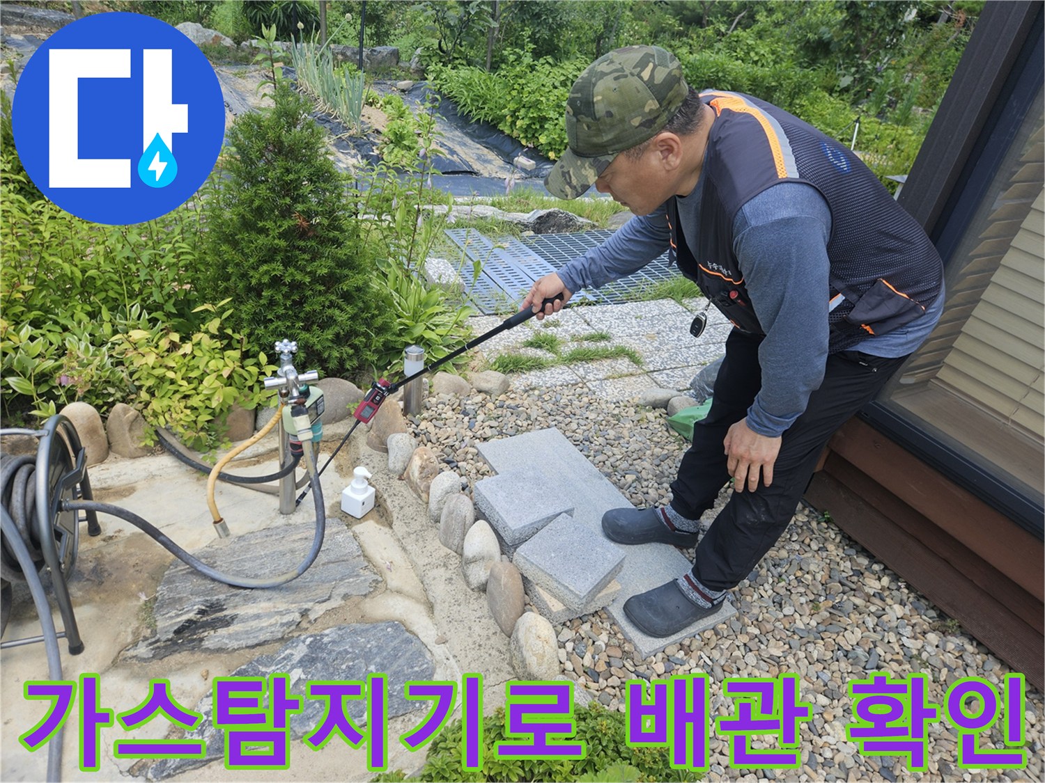 가스 탐지기를 사용하여 마당 외부 배관의 누수 지점을 추적하는 모습
