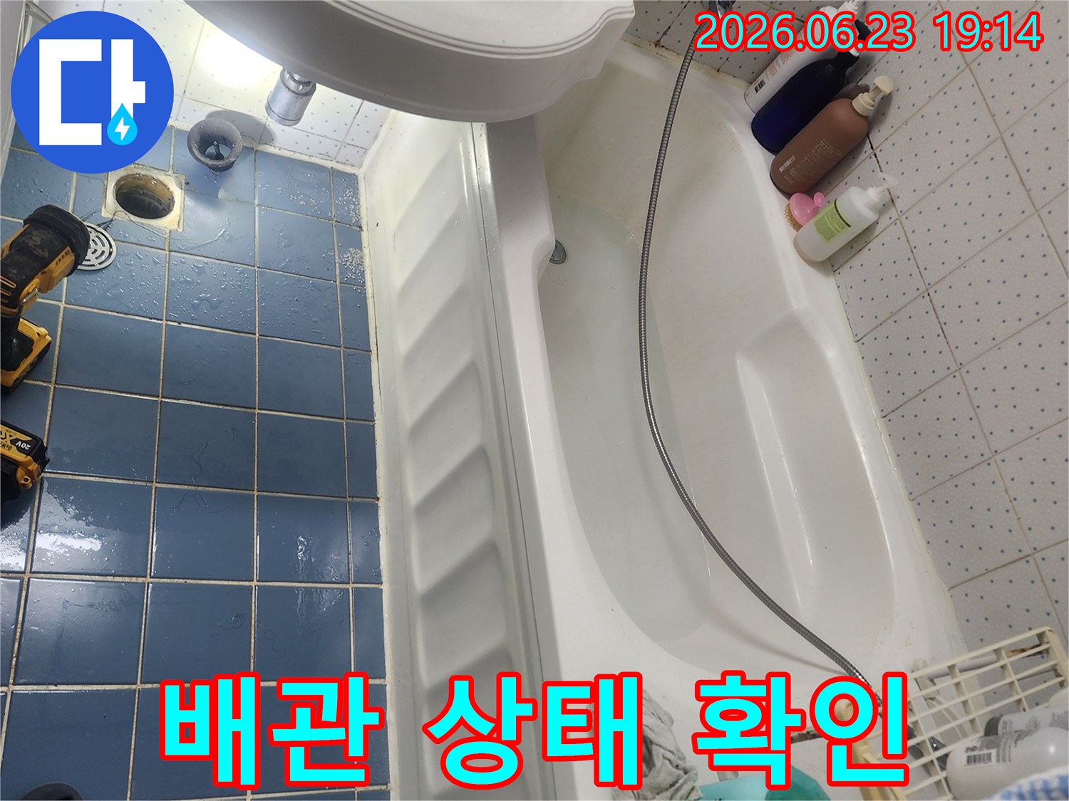 사가정로 아파트 욕실 바닥 타일이-젖어 있는 누수 현장에서-배관 상태를 확인하는 모습입니다.