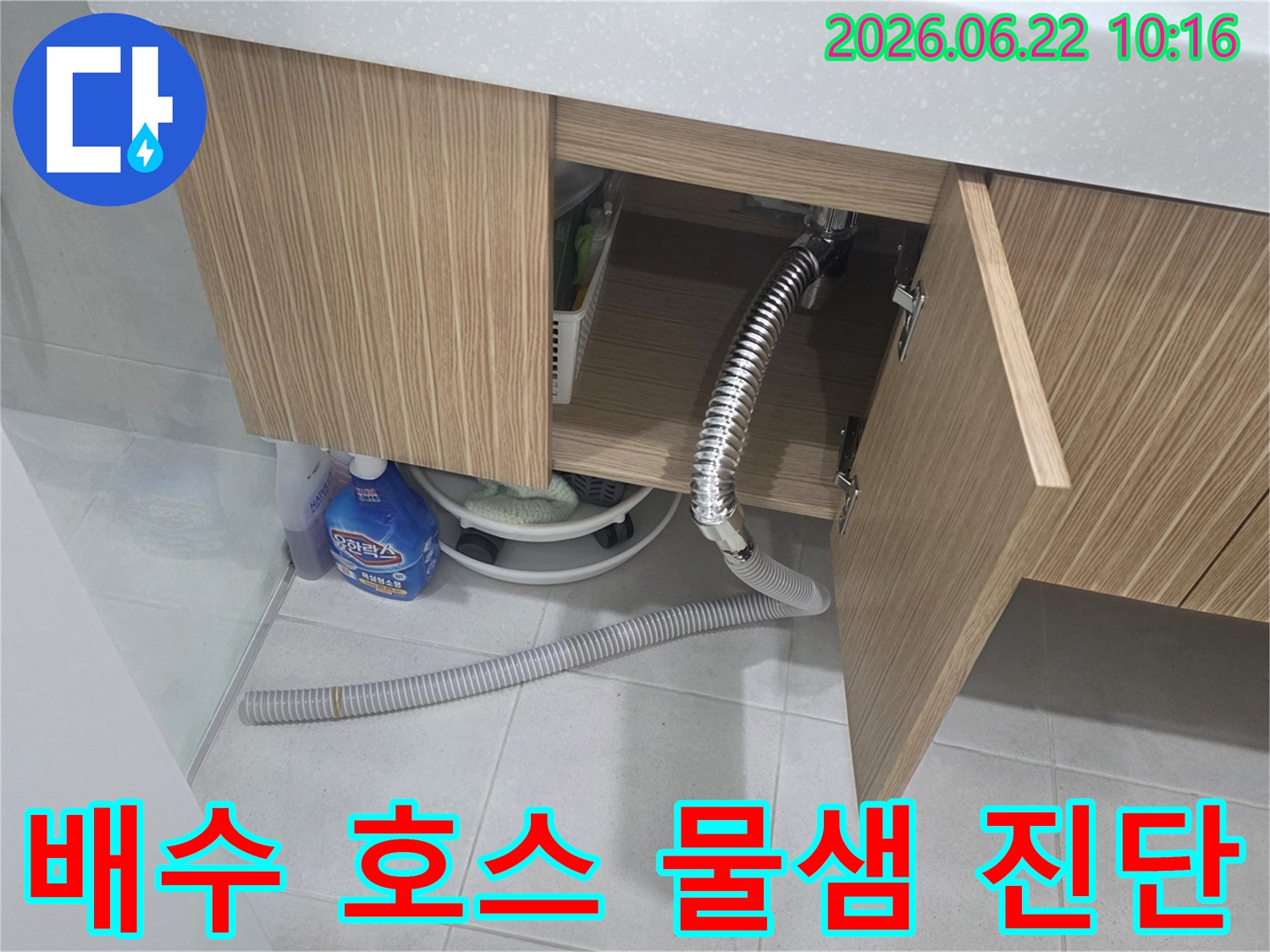 세면대 하부장 아래에서 배수 호스 문제로 인해 물이 새는-누수 현장을 정밀하게 진단하는 모습