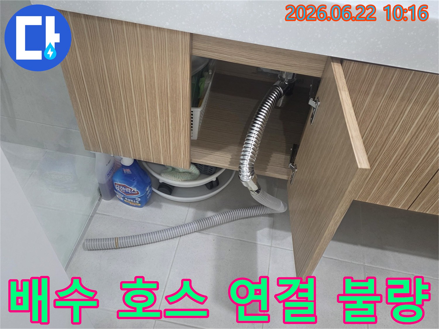 세면대 하부장 아래에서 배수 호스가 제대로 연결되지 않아-물이 새는 현장을 점검하는 모습