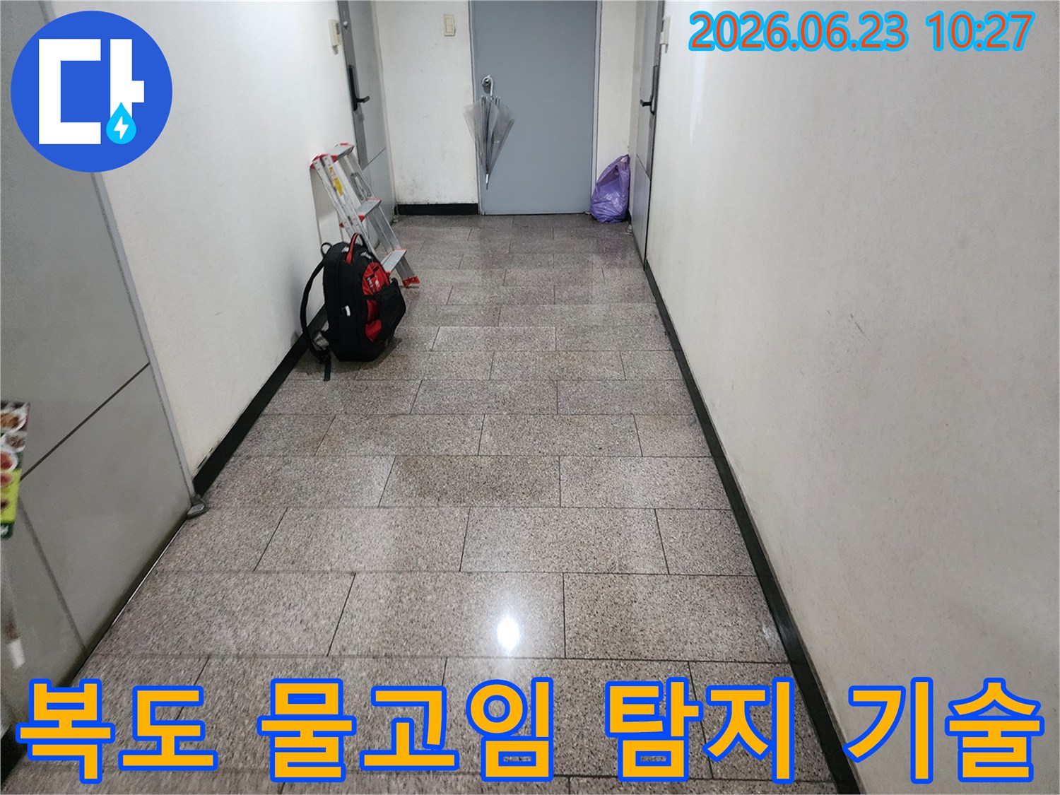 이 이미지는-송파구-주택-복도-바닥에-누수로-인한-물고임이-발생하여-누수-탐지-기술의-중요성을-보여줍니다