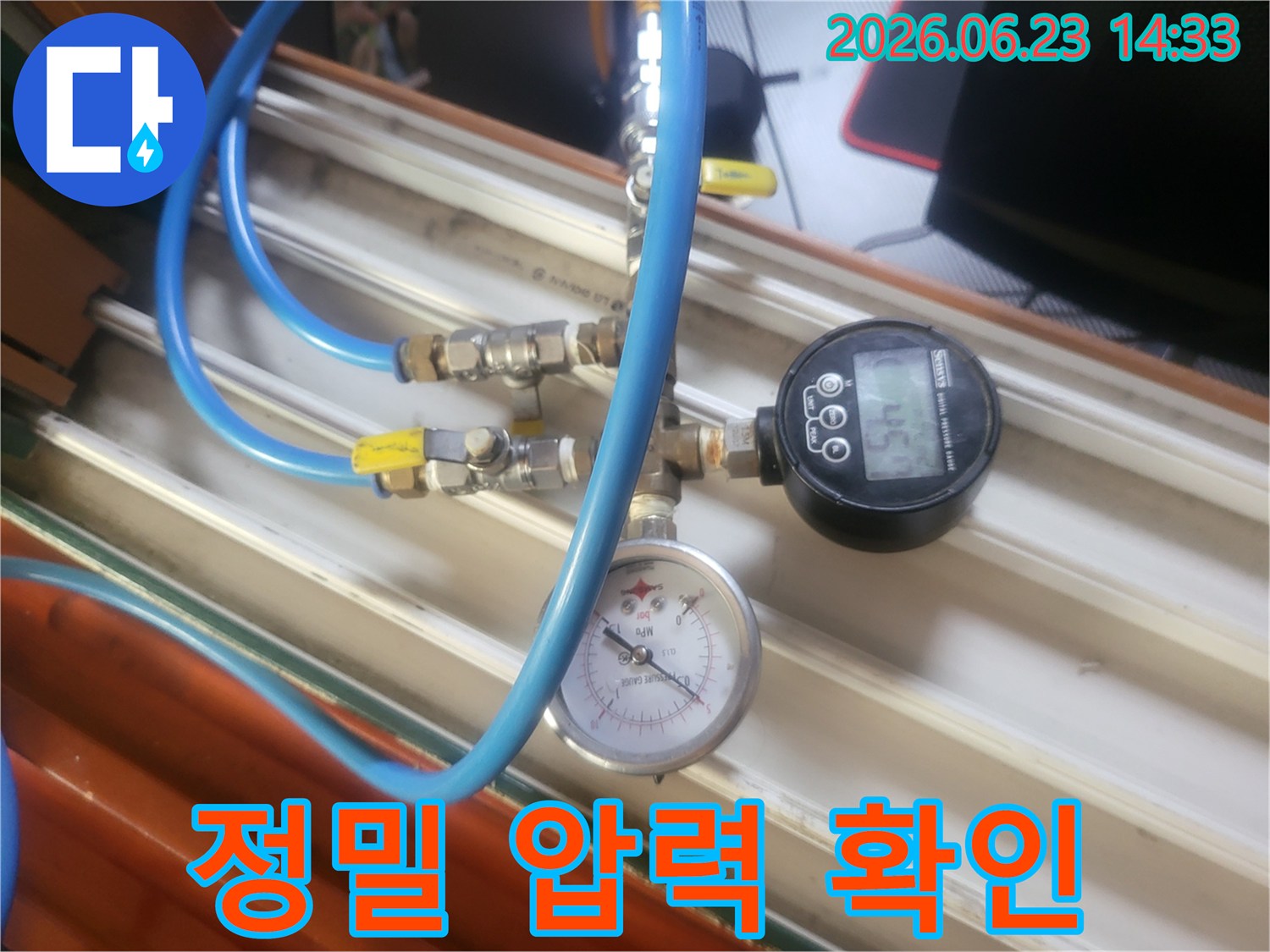 파란색 호스와-다양한 밸브-그리고 압력계가 연결된-누수 탐지 장비가-작동 중인 모습입니다.