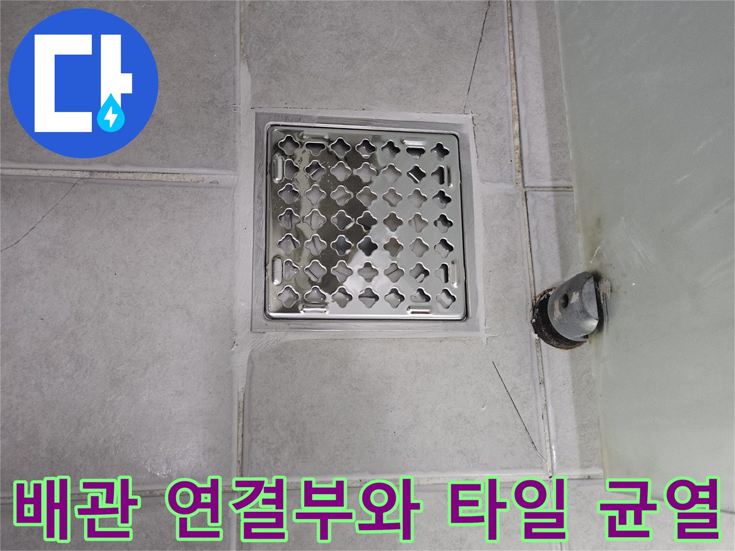 욕실 하수구 부근 - 노후된 배관과 갈라진 타일의 모습