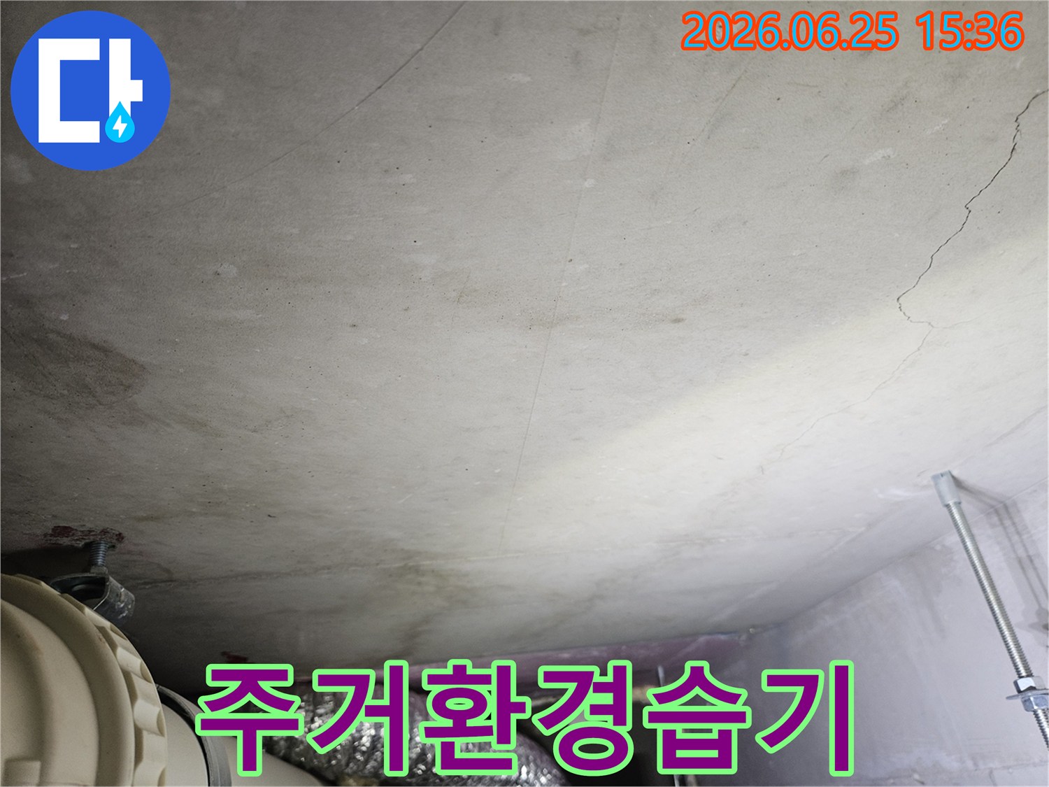 콘크리트 천장에 넓게 퍼진 물 얼룩과-습기로 인한 변색이 주거 환경에 미치는 악영향을 보여주는 누수 현장 사진입니다.