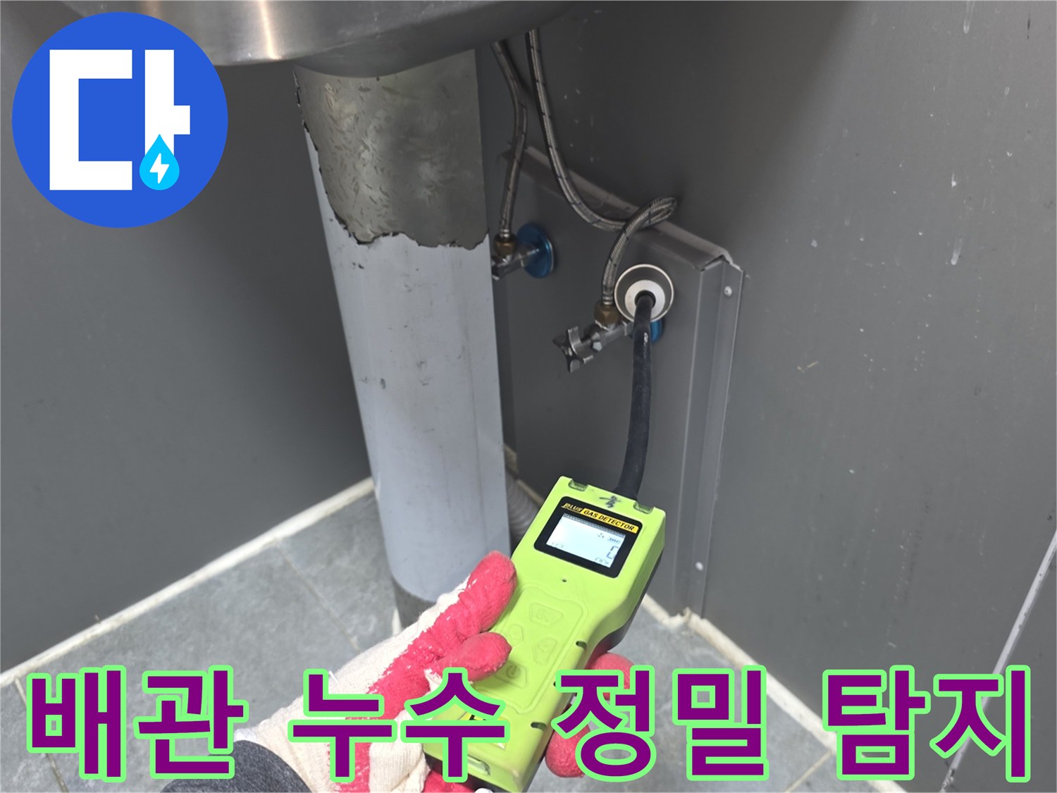 누수-전문가가-첨단-탐지기를-이용해-싱크대-하부-배관의-누수-여부를-확인하는-장면