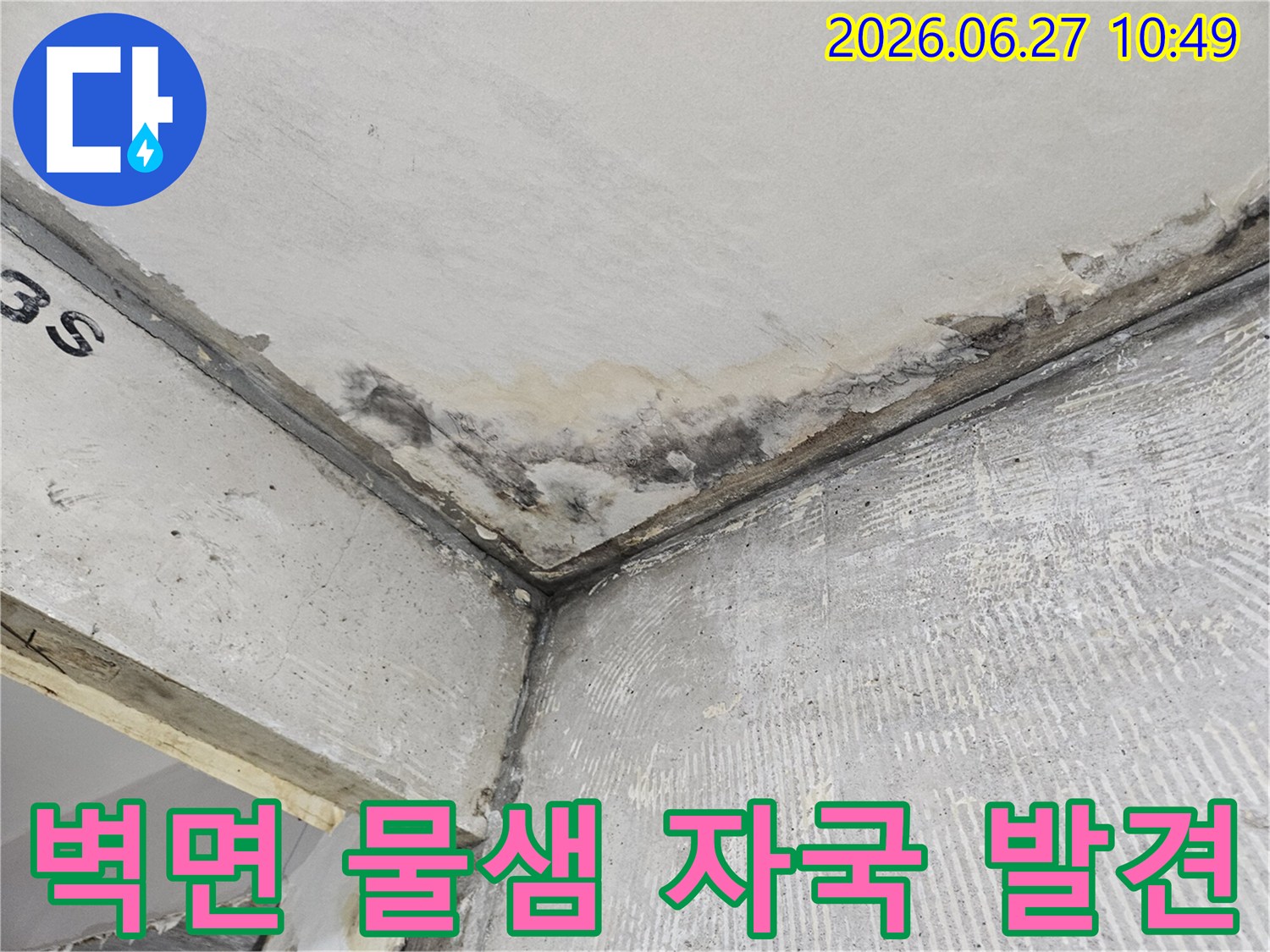콘크리트 벽면과 천장 모서리에-오래된 듯한 물샘 자국과-습기로 인한 변색이 선명하게 나타나 있습니다