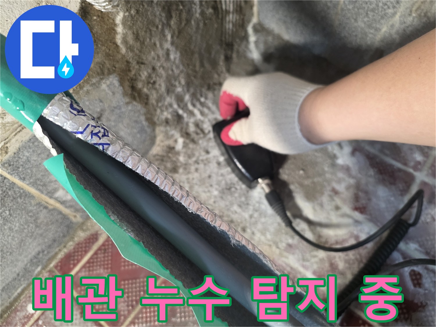 누수 부위를 확인하기 위해 전문 장비를 조작하는 엔지니어의 손