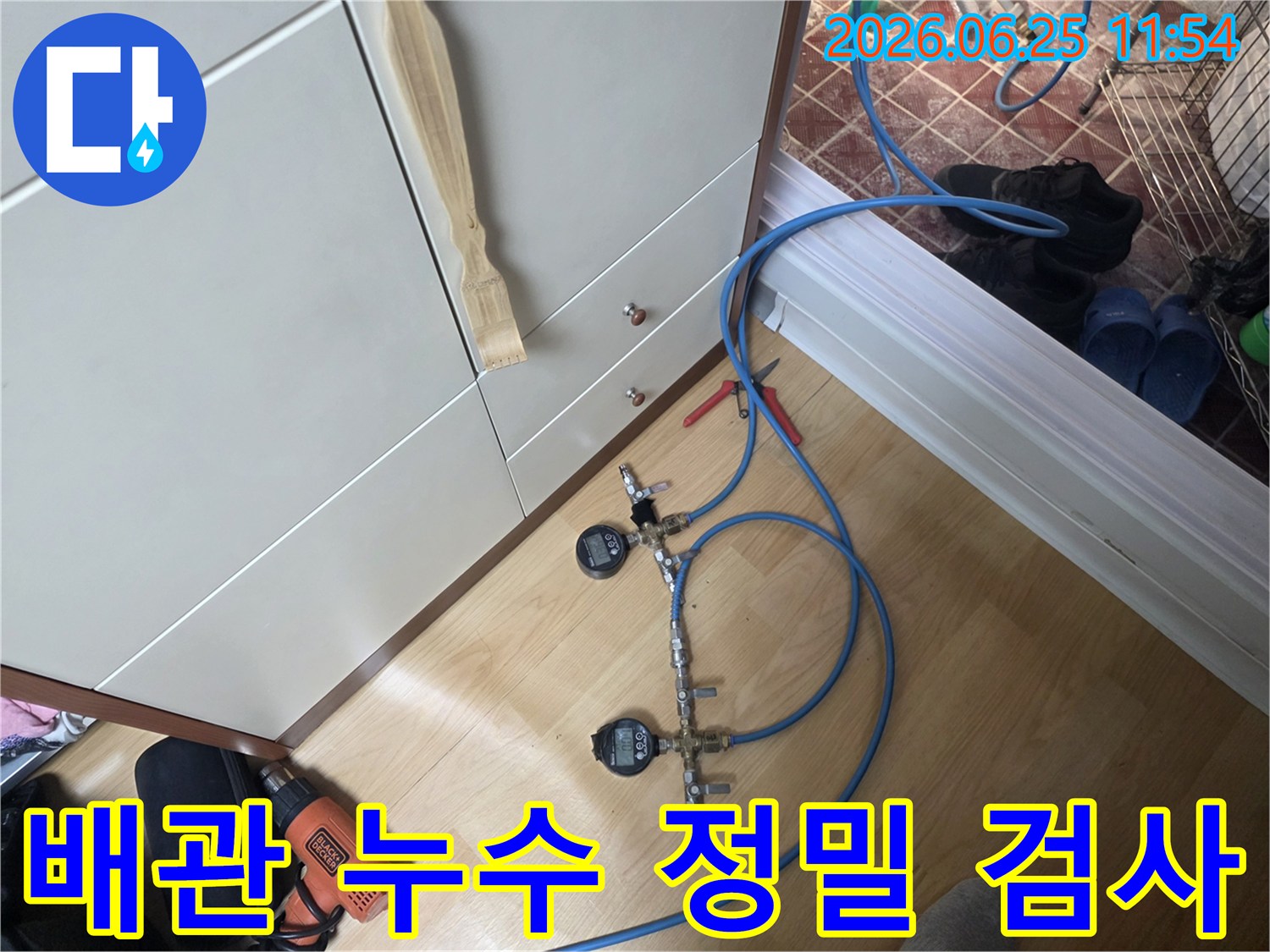 누수 엔지니어가 배관의 압력을 세밀하게 모니터링하기 위해 디지털 압력 게이지가 연결된 가압 테스트 장치를 사용하고 있습니다