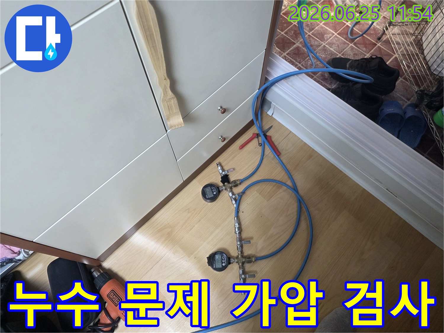 누수 엔지니어가 배관의 압력을 세밀하게 모니터링하기 위해 디지털 압력 게이지가 연결된 가압 테스트 장치를 사용하고 있습니다