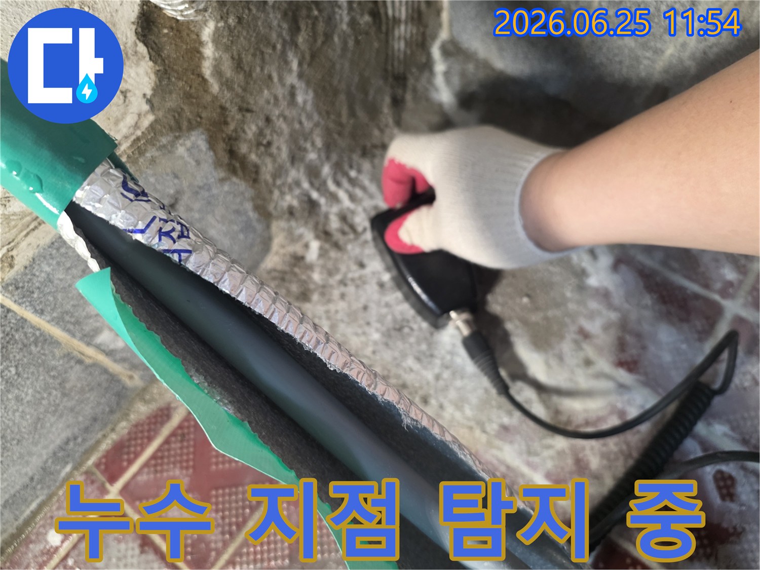 누수 탐지 전문가가-고성능 청음식 탐지기로-벽면 내부의 배관 상태를-면밀히 검사하고 있습니다