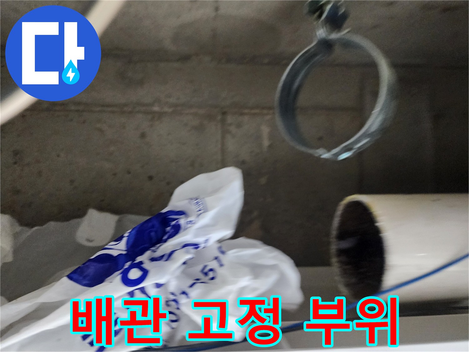 배관을 지지하는 금속 클램프와 흰색 배관의 모습