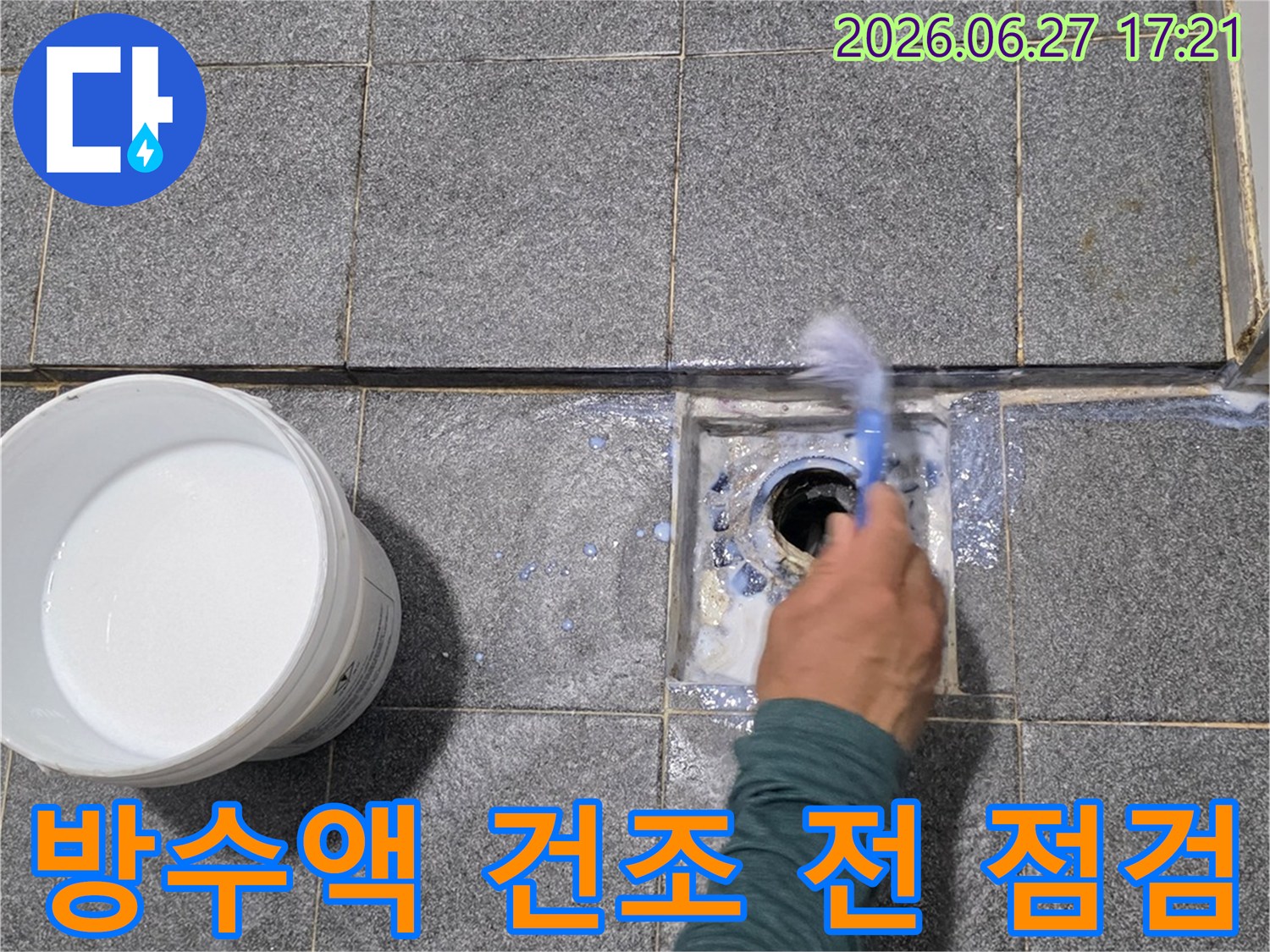 숙련된 기술자가-하수구 주변에 도포된-방수액의 건조 전 상태를-꼼꼼하게 최종 점검하고 있습니다.