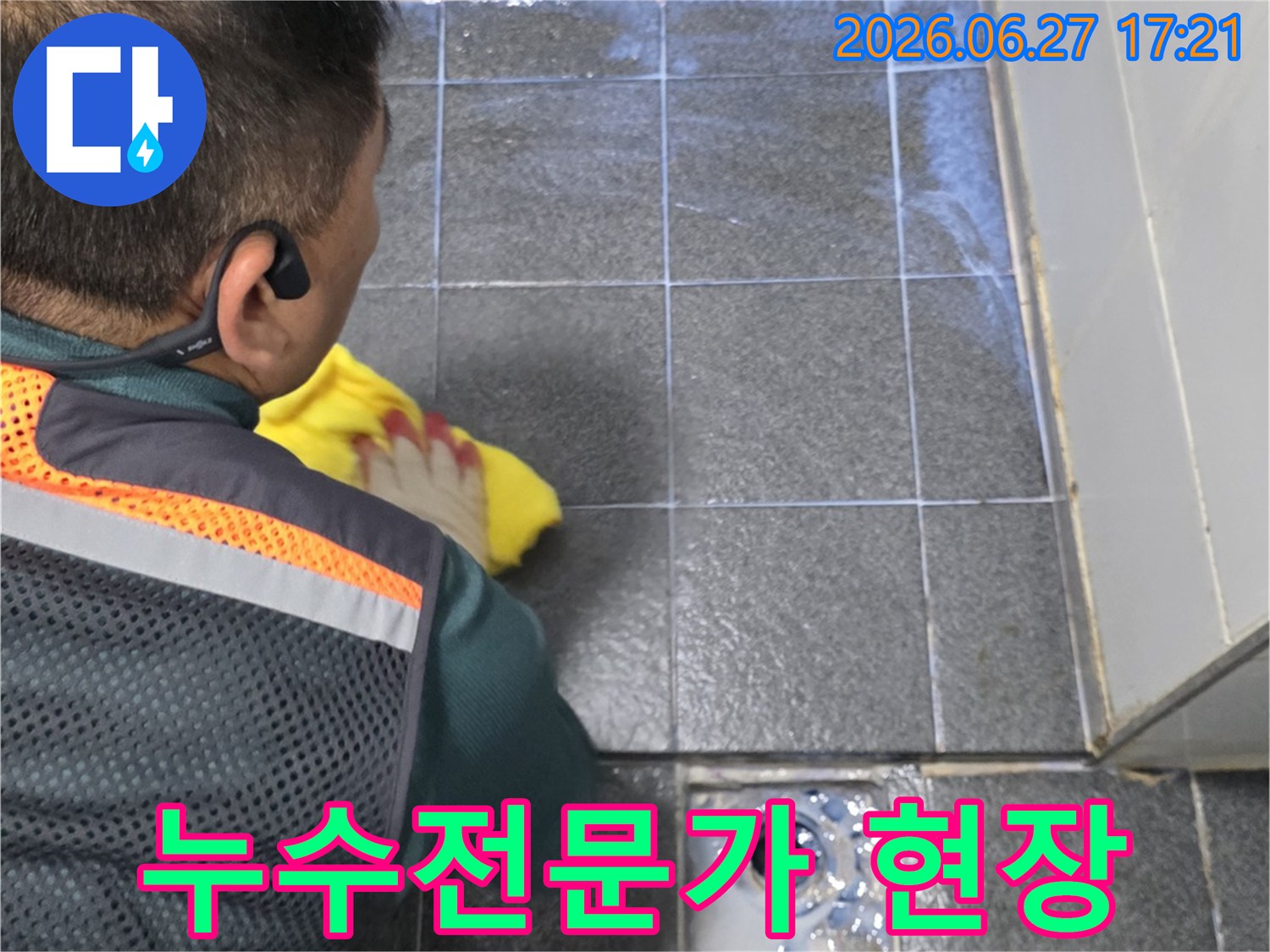 숙련된 누수 전문가가-욕실 벽면의-누수 흔적을-정밀하게 분석하며-원인을 파악하는 모습