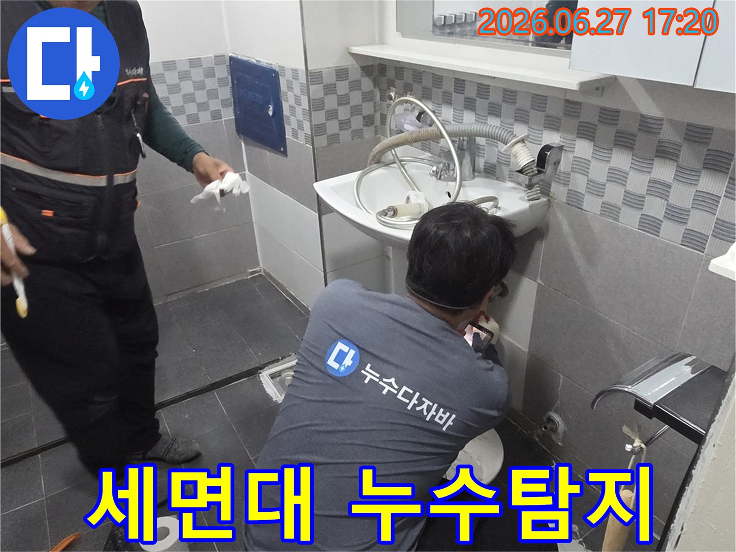 욕실 세면대 아래 배관에서-누수 지점을 정확히 파악하기 위해-집중적으로 작업하는 엔지니어의 모습