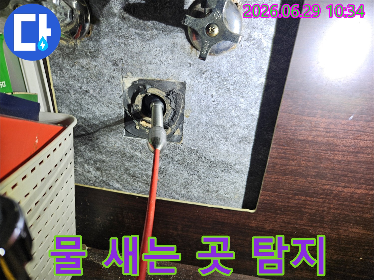 욕실 벽면 배관에서 물이 새는 지점을-내시경 카메라로 정밀하게 탐지하여-정확한 수리 계획을 세우는 모습