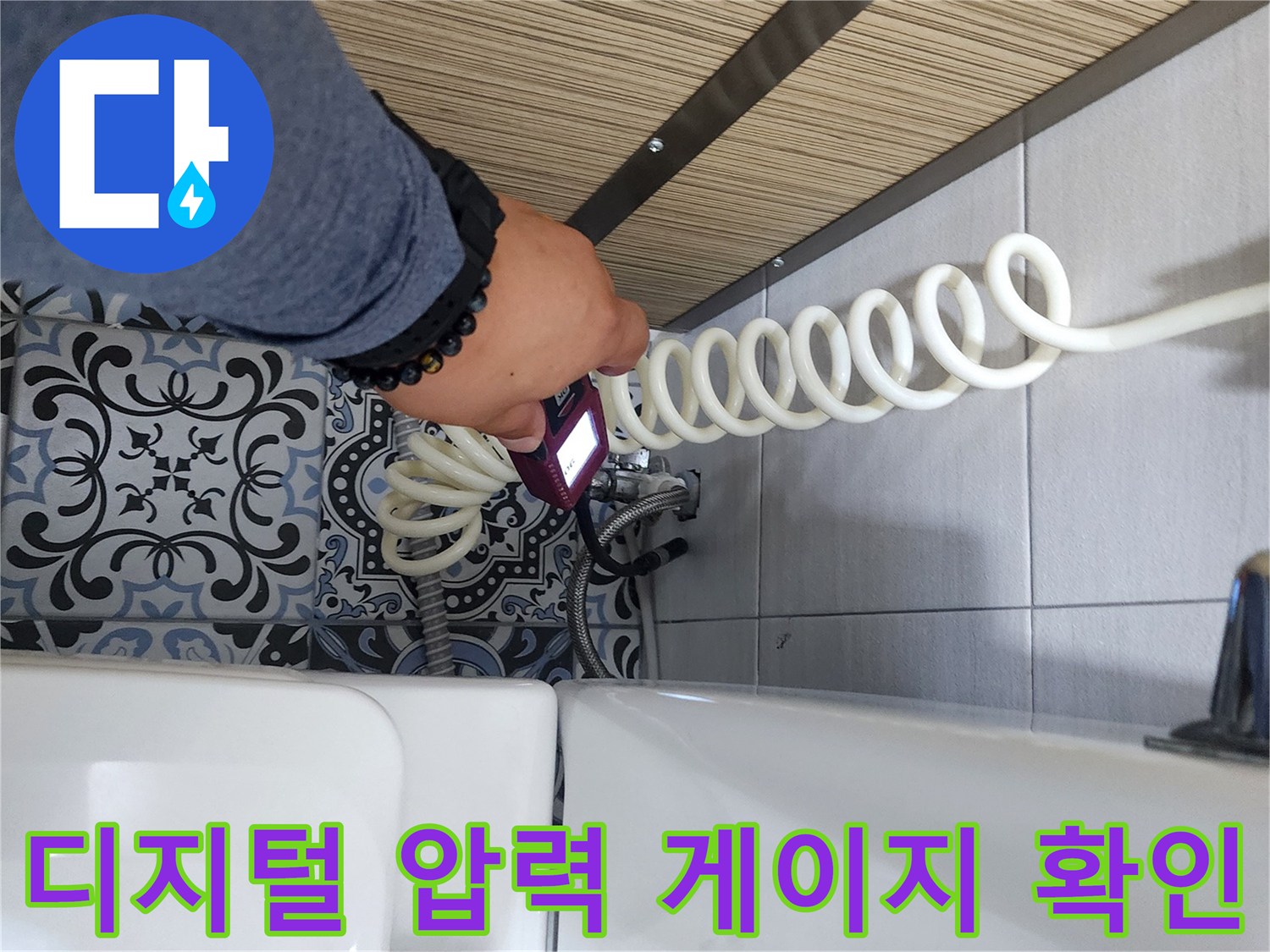 배관의 수압 상태를 측정하기 위해 디지털 장비를 사용하고 있는 현장 사진입니다.