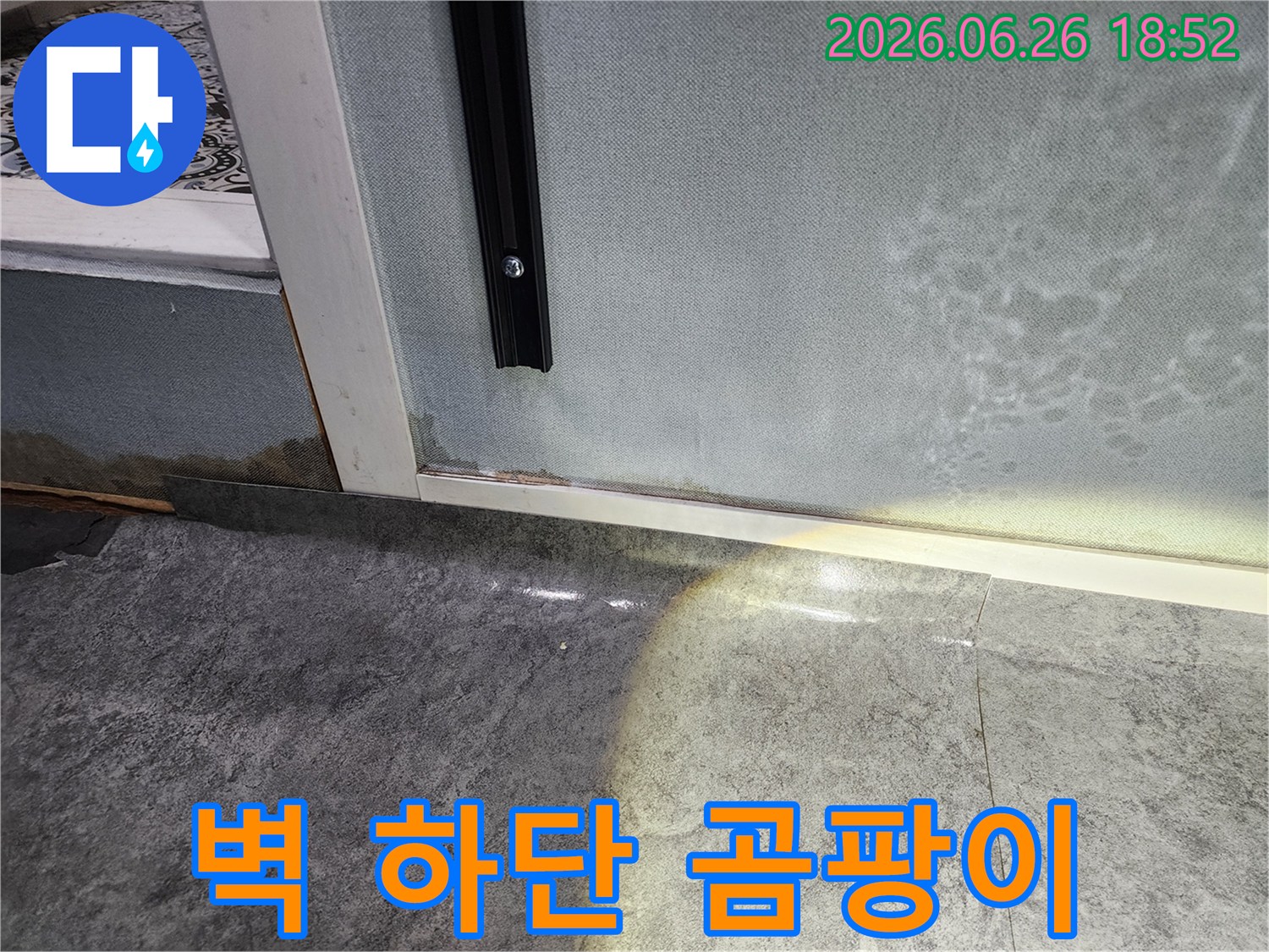 벽면 하단에 발생한-누수로 인한-습기와 곰팡이 흔적을 보여주는-피해 현장 사진입니다